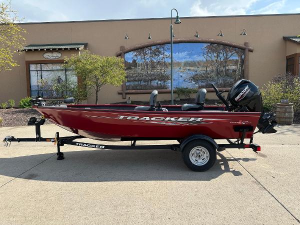 2025 Tracker Super Guide V-16 T boat on trailer, red exterior, parked outdoors.