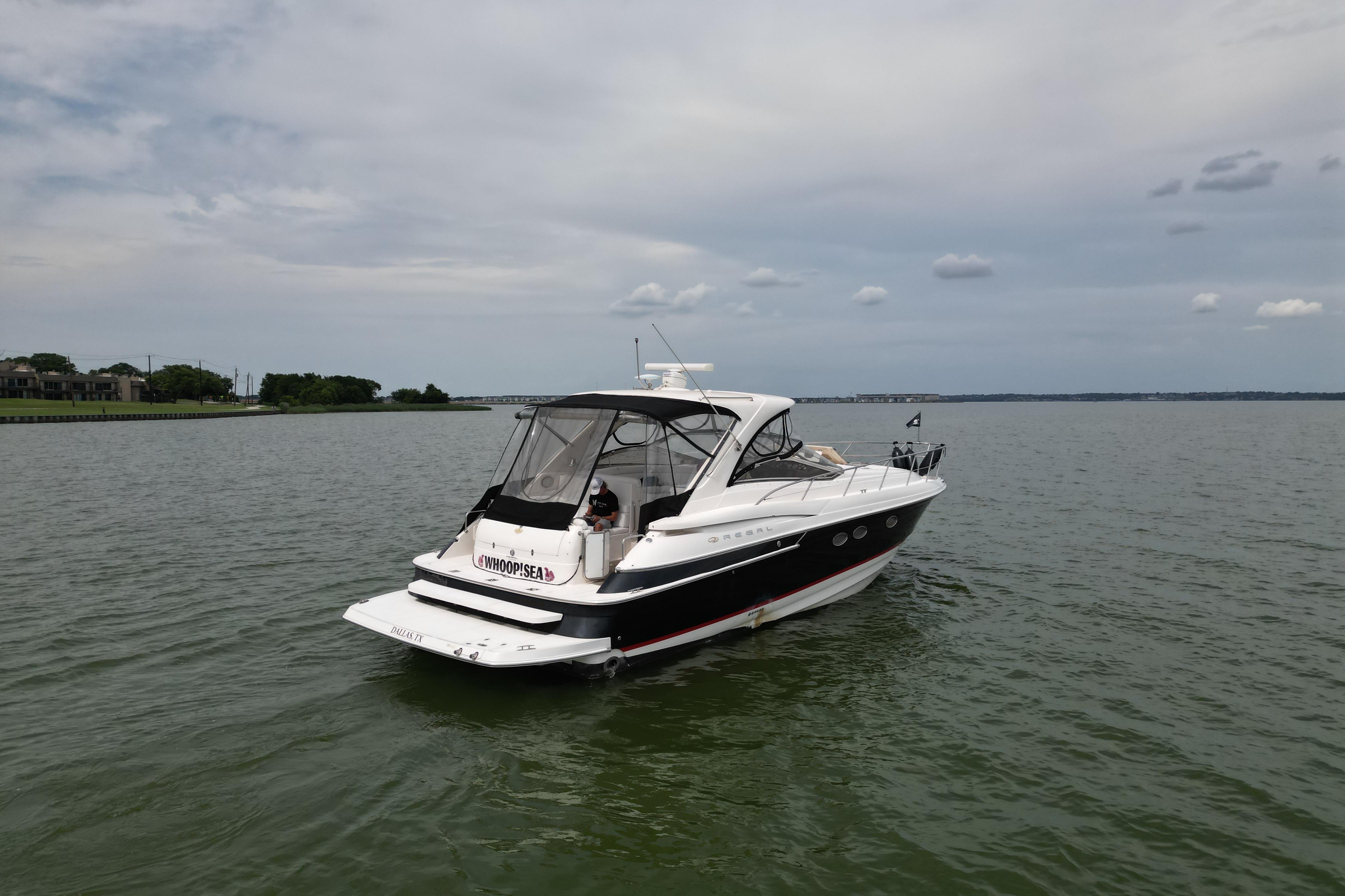 2005 Regal Commodore 4260 yacht cruising on calm waters under a cloudy sky.