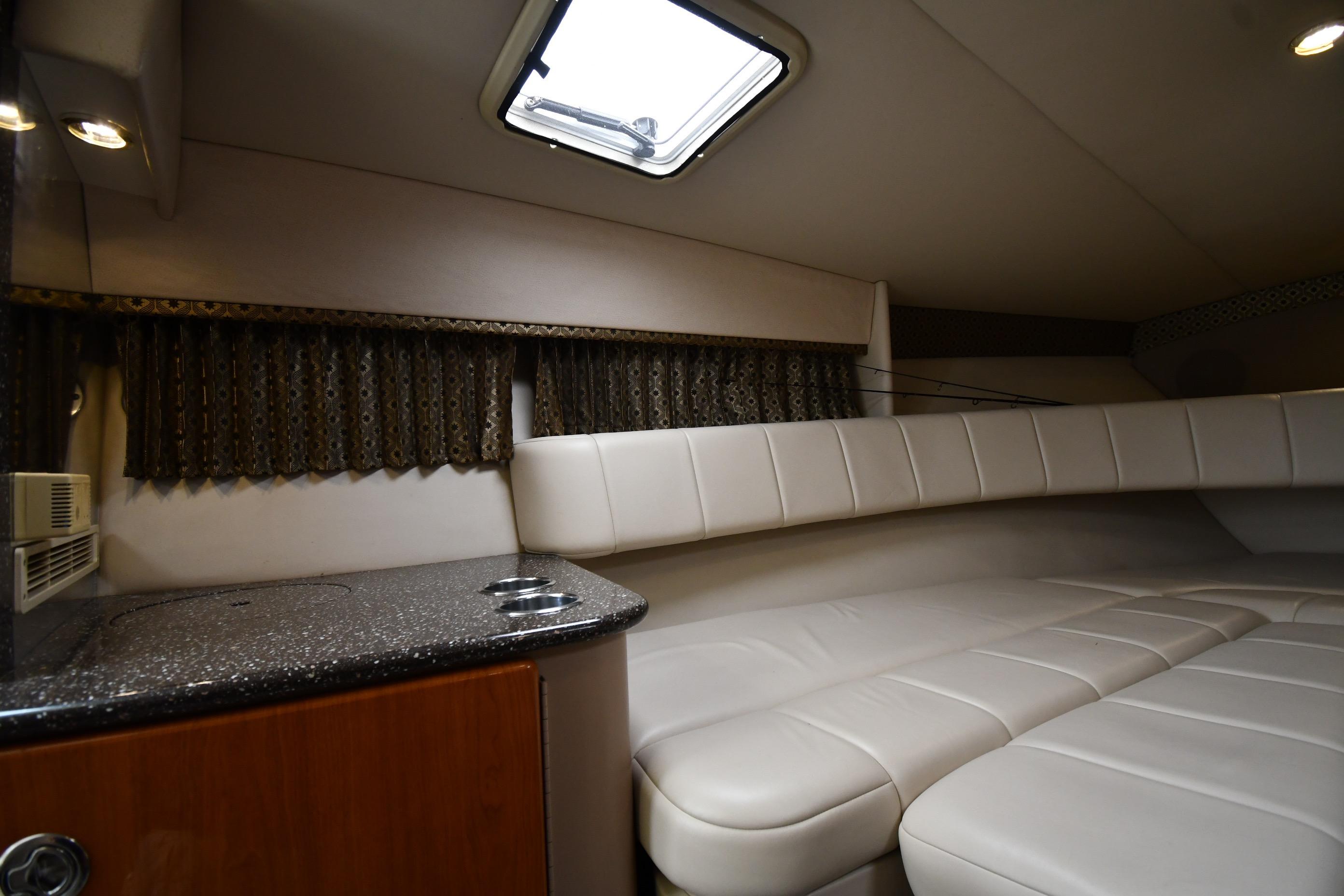Interior of 2004 Formula 330 Sun Sport boat with plush seating and compact kitchenette.