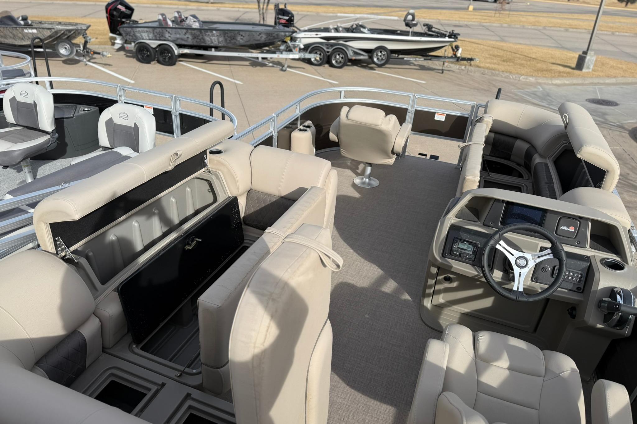 2025 Sun Tracker SportFish 20 DLX pontoon boat interior with seating and steering console.