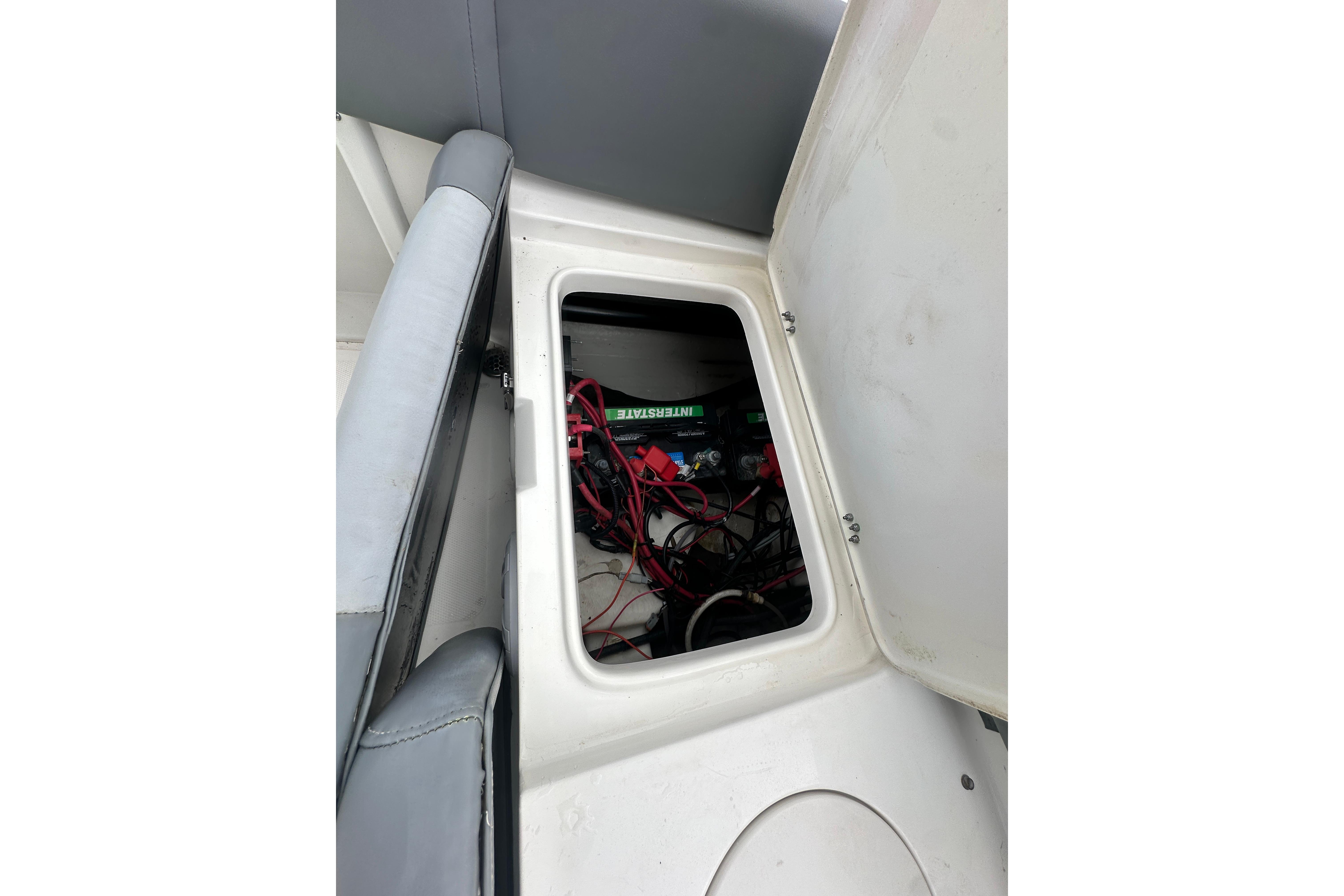 2023 NauticStar 2102 Legacy boat storage compartment with visible wiring and battery.