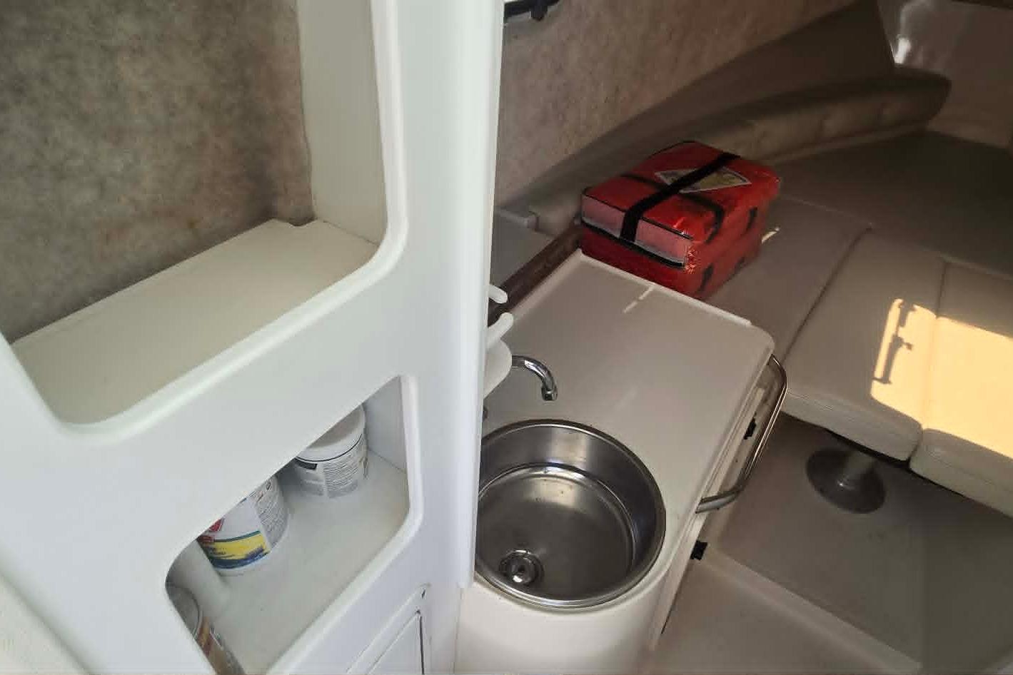 Interior of 2003 True World Marine 286 boat with sink and seating area.