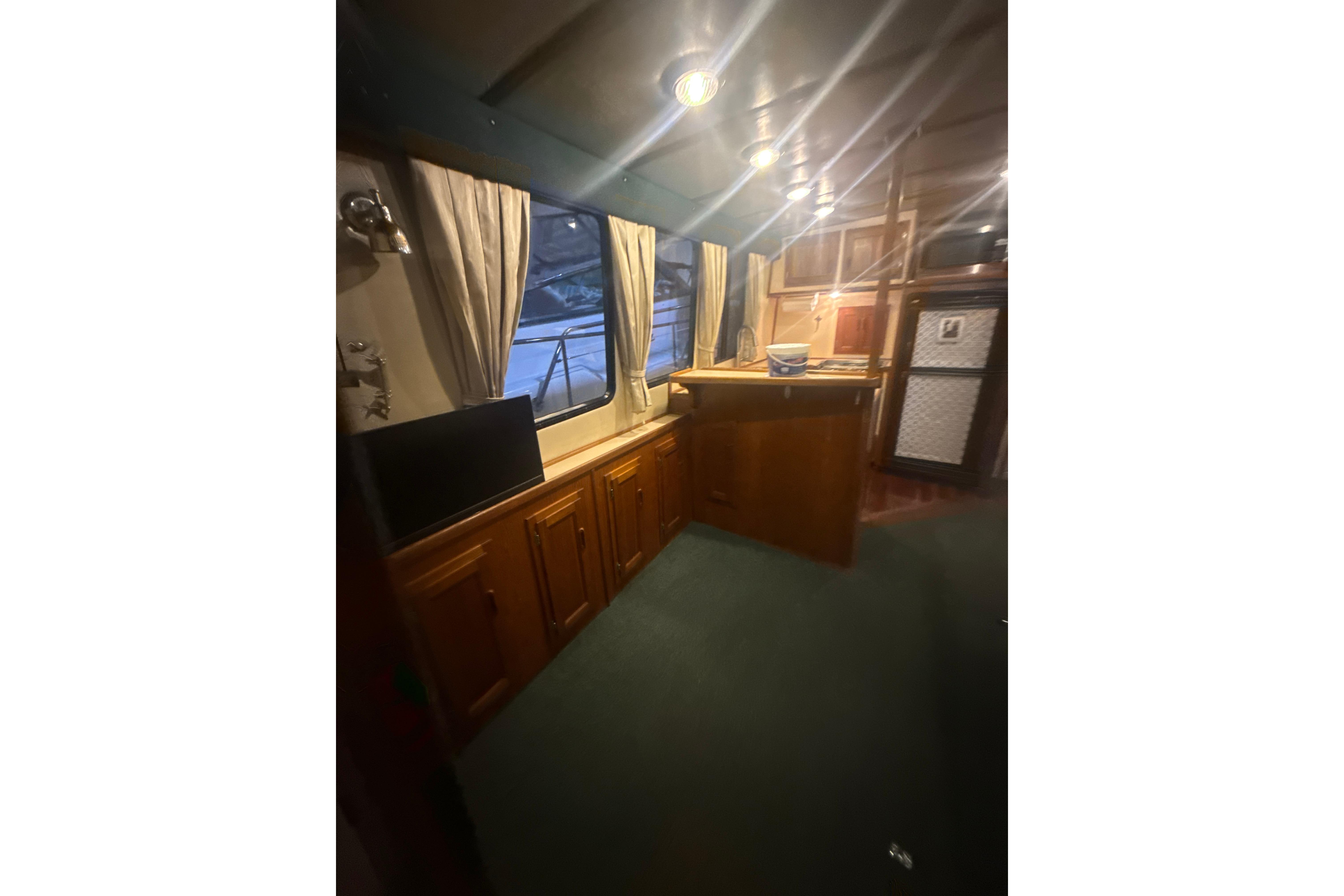 Interior of a 1997 Nordic Tug 42, featuring wood cabinetry and a cozy seating area.