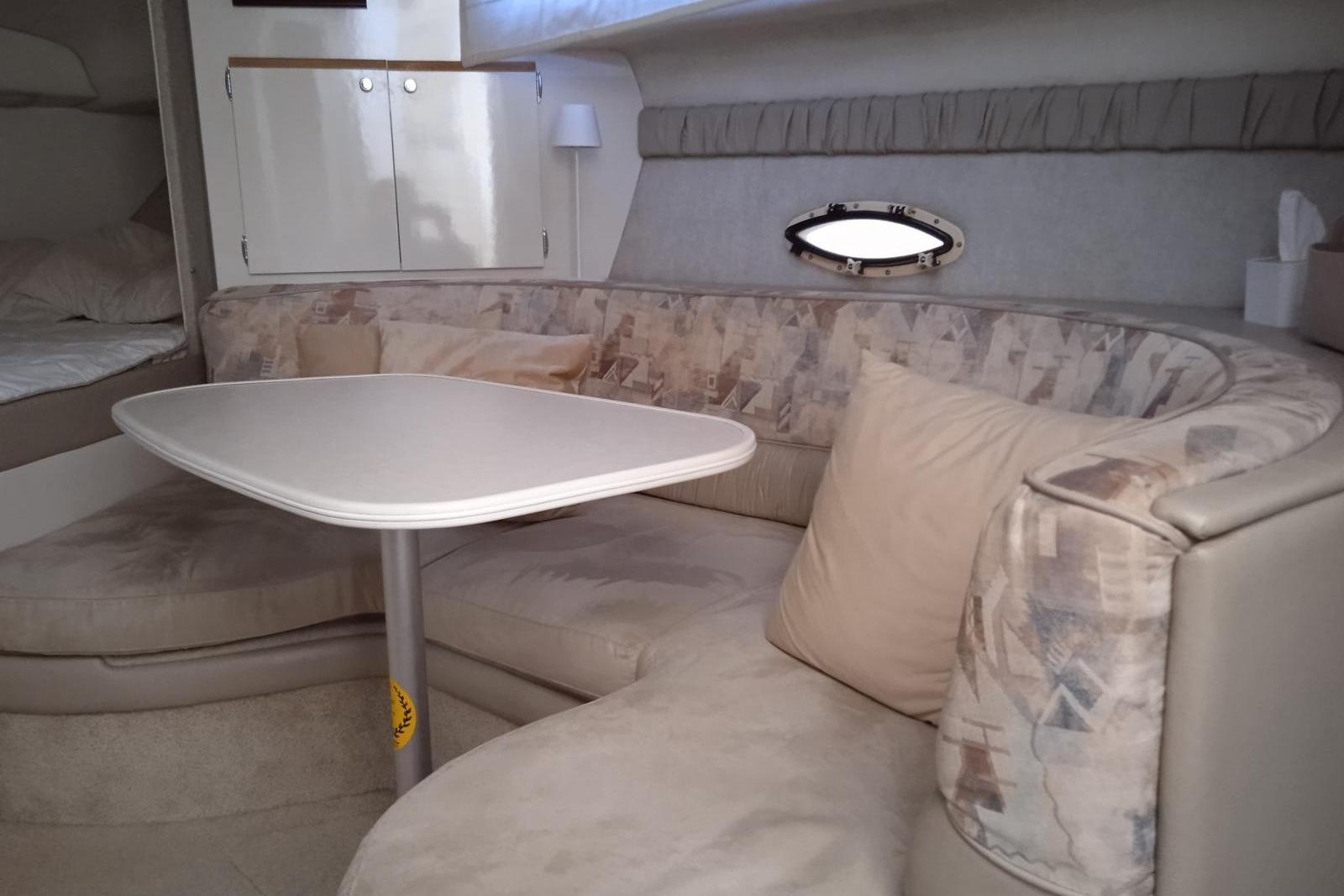 Interior of a 2004 Bayliner 3055 Ciera with cozy seating and table.
