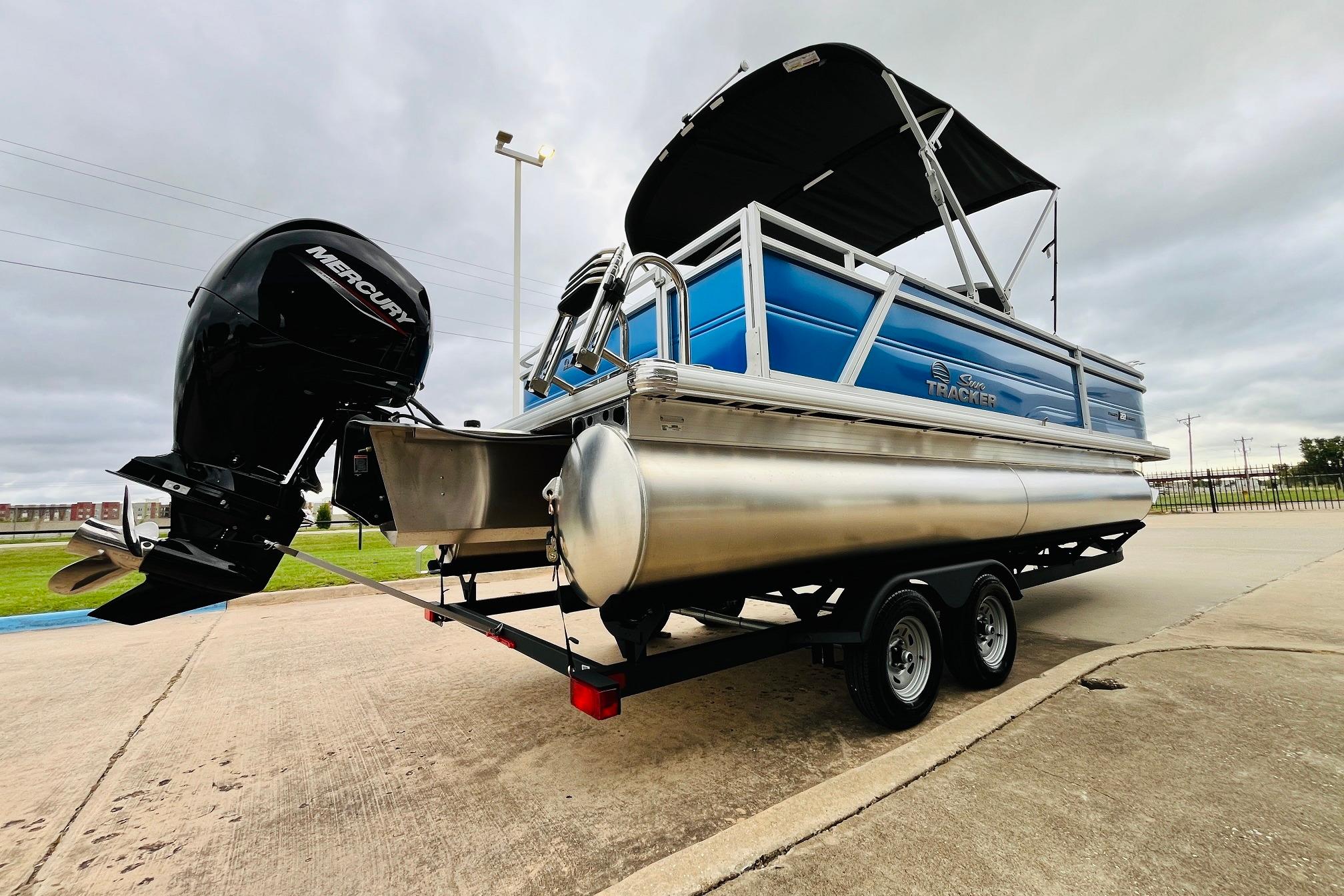 2026 Sun Tracker Party Barge 22 RF DLX pontoon boat on trailer, featuring Mercury outboard motor.