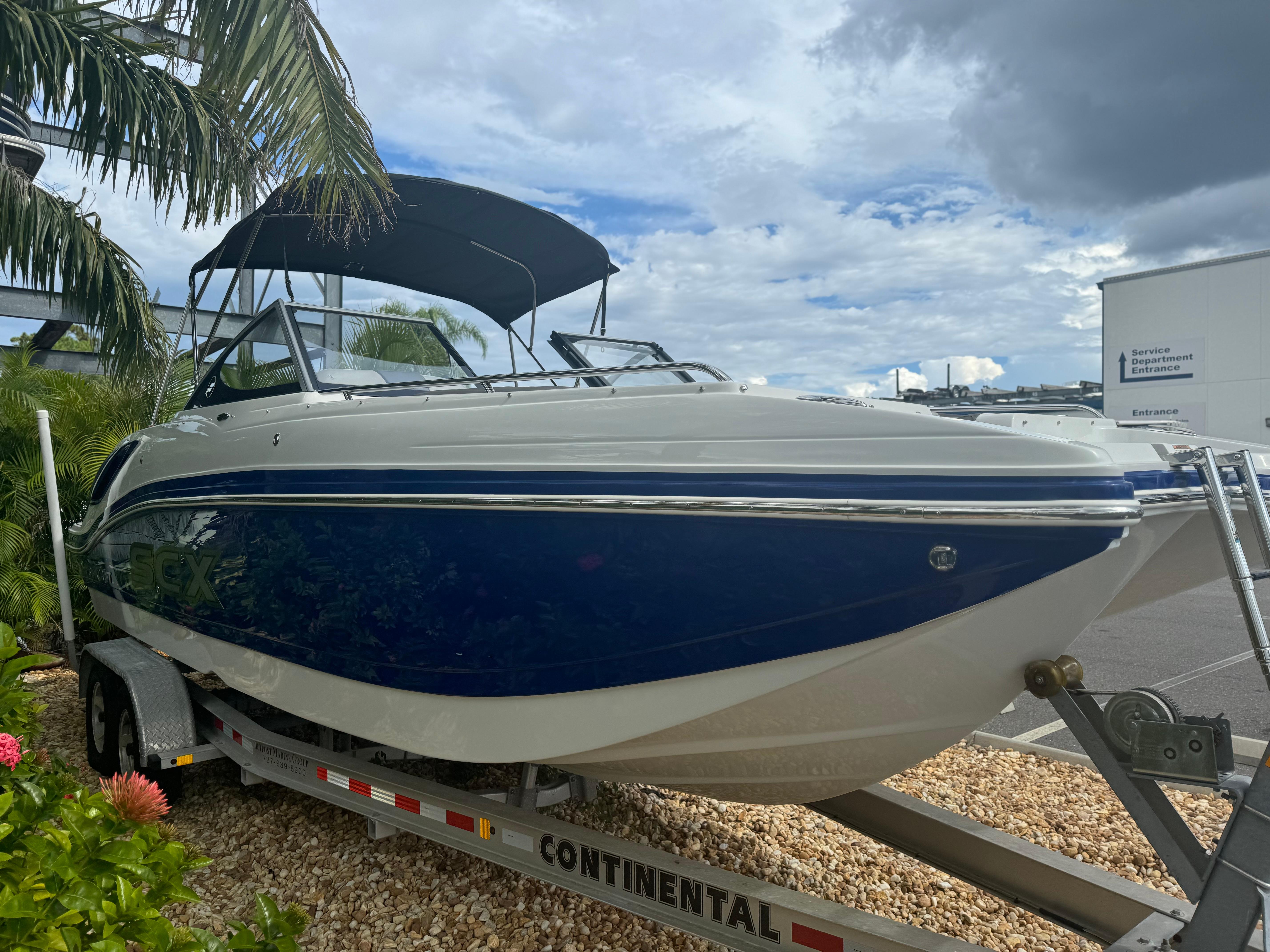 2017 Starcraft 230 OB SCX EXT boat on trailer, parked outdoors under cloudy sky.