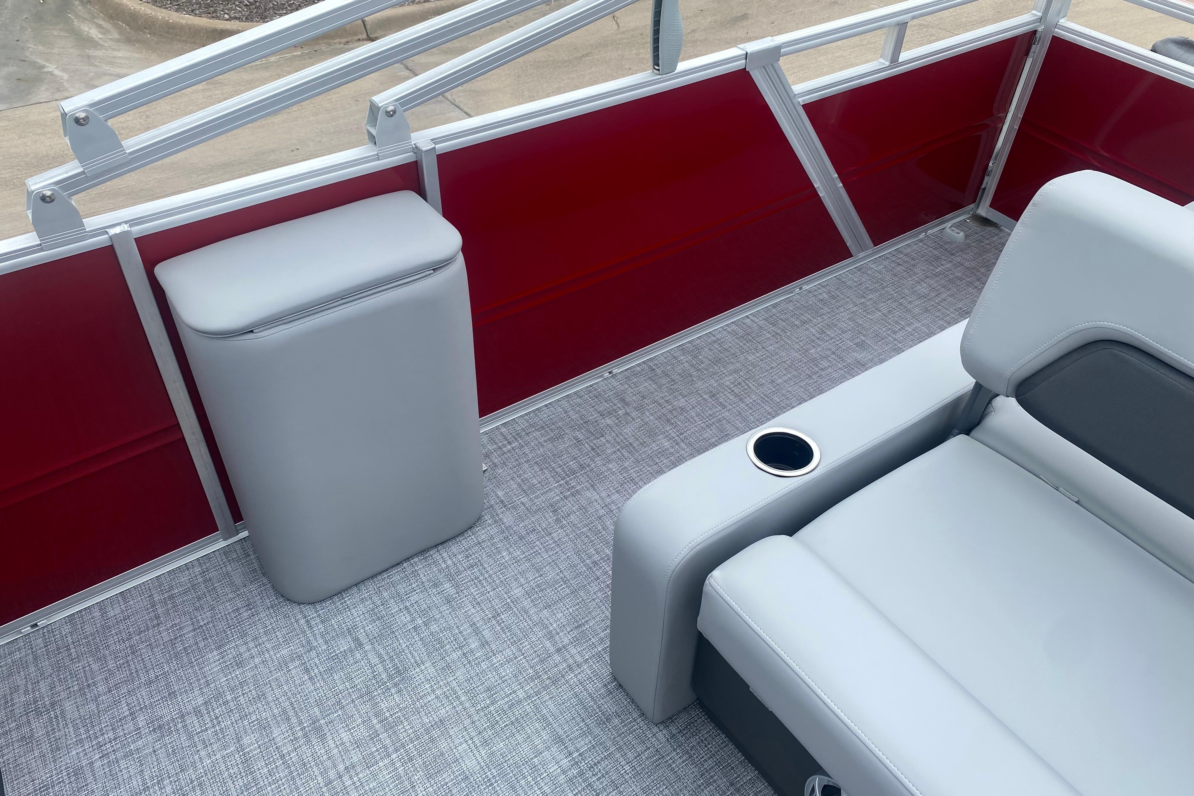 Interior of 2026 Sun Tracker Party Barge 22 RF DLX with gray seating and red paneling.