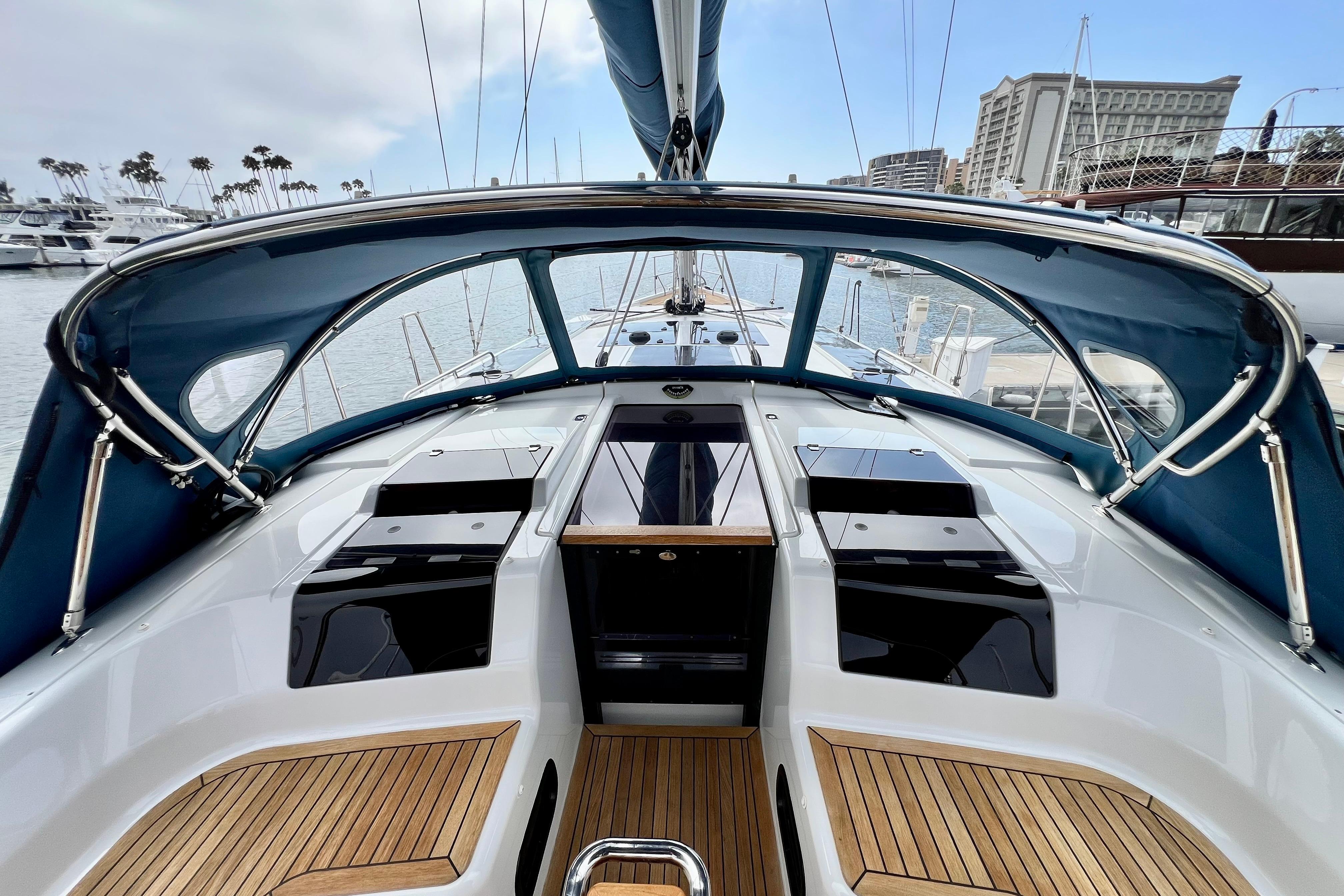 Interior view of a 2016 Hanse 455 sailboat cockpit with wooden flooring and blue canopy.
