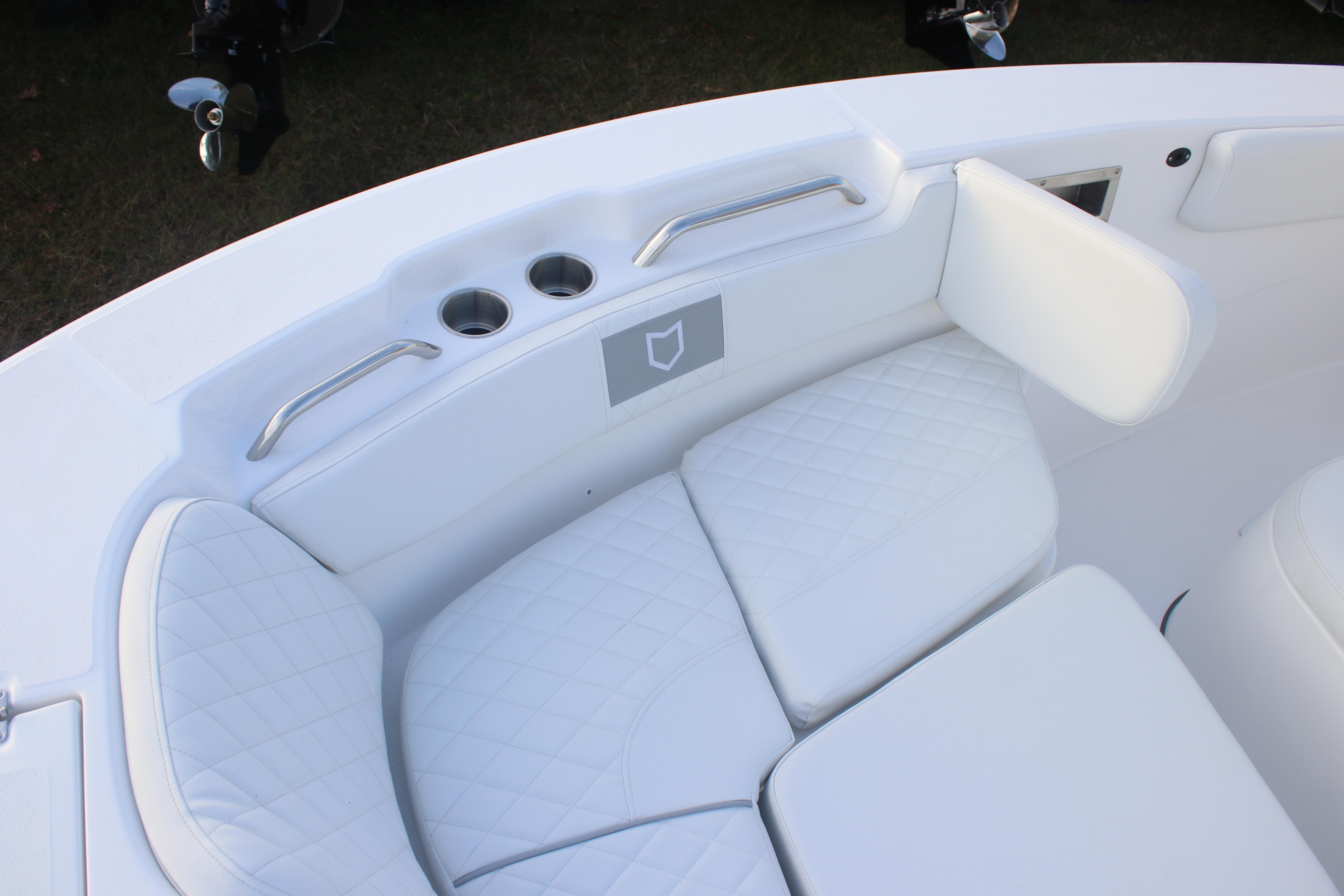 2026 Sea Fox 228 Commander boat interior with white cushioned seating and cup holders.