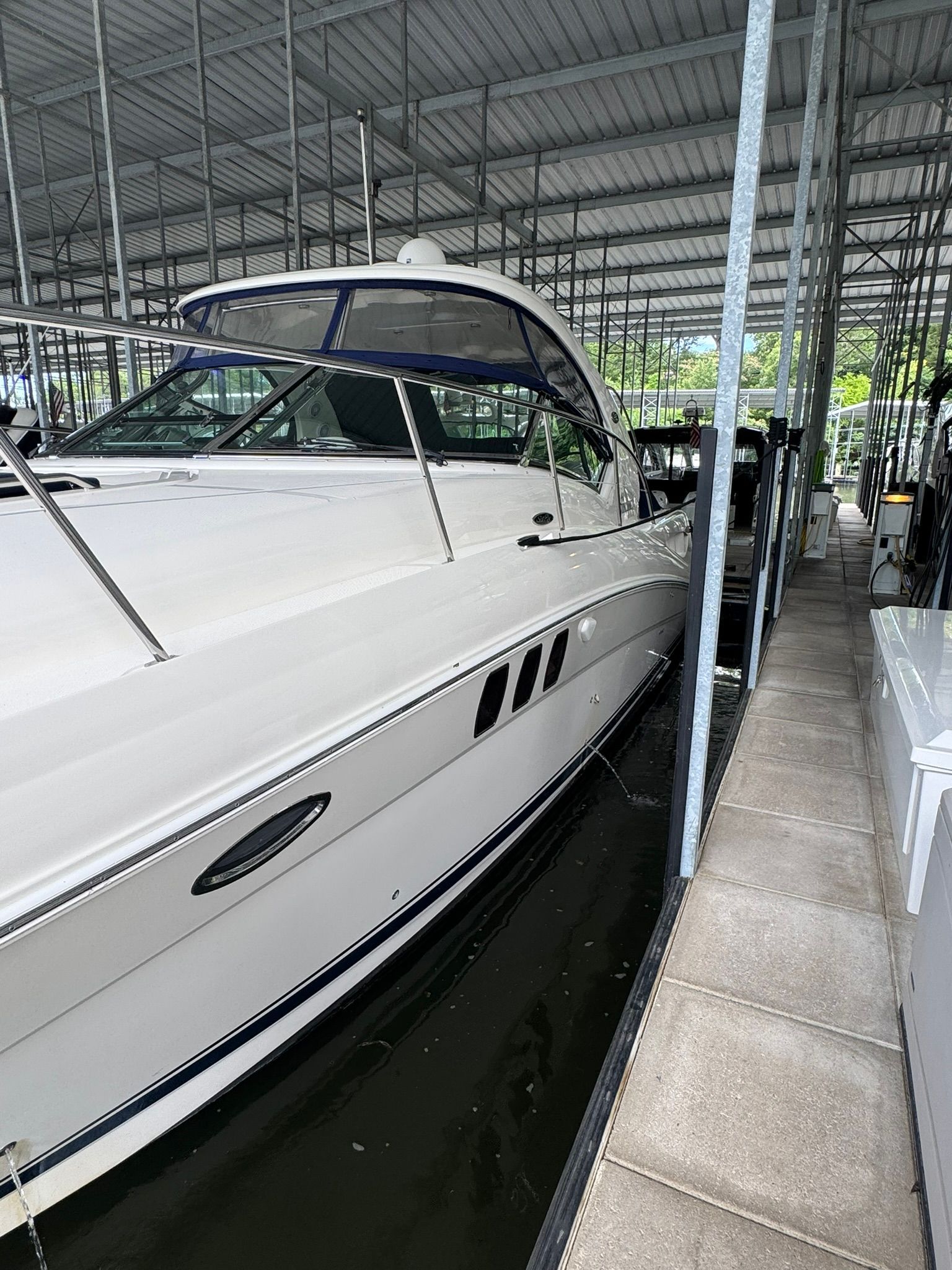 A 2007 Sea Ray 40 Sundancer docked in a covered marina.