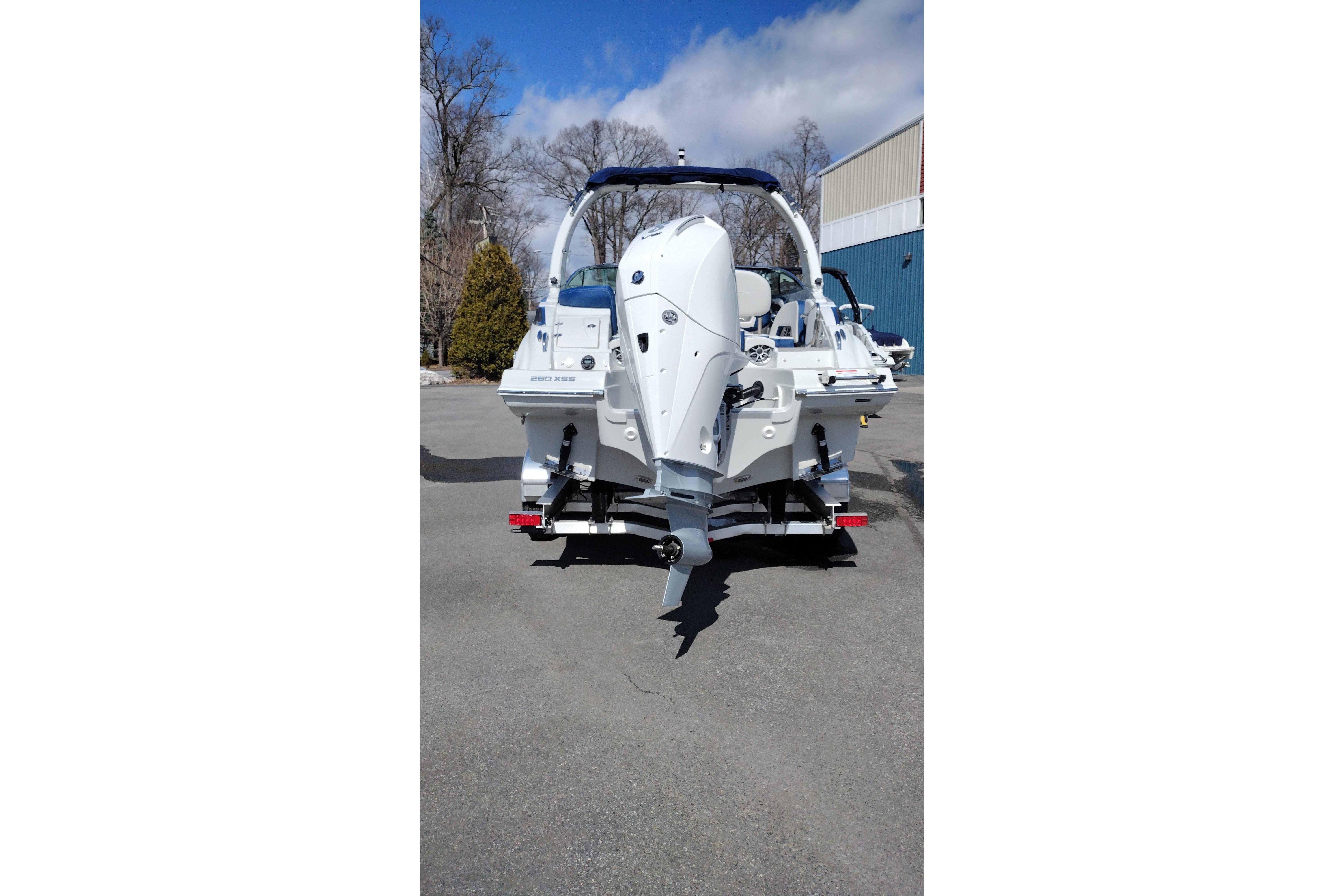 2026 Crownline 260 XSS boat rear view with outboard motor in a parking area.
