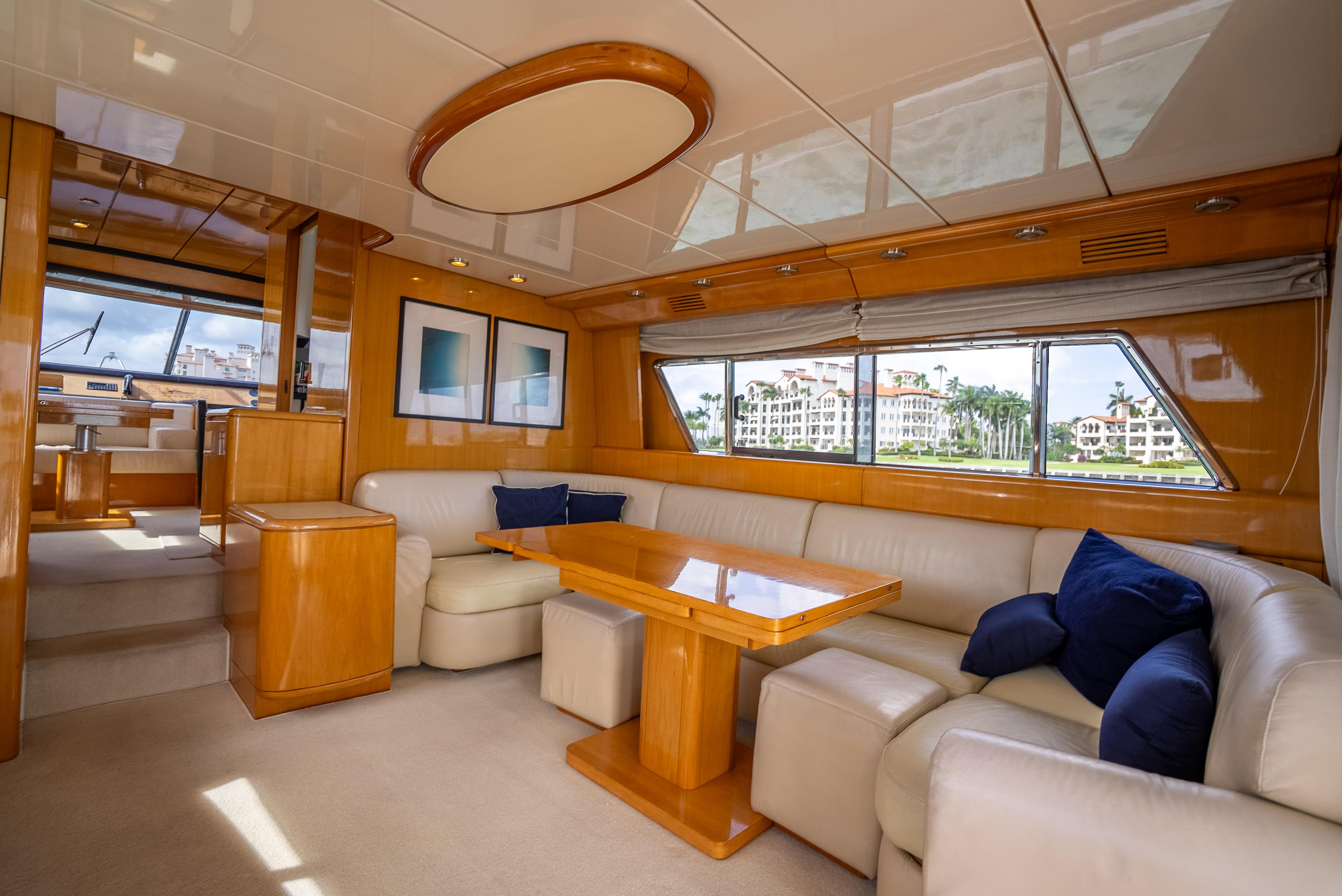 Luxurious interior of a 1995 Sanlorenzo 62 yacht with elegant seating and wood finishes.