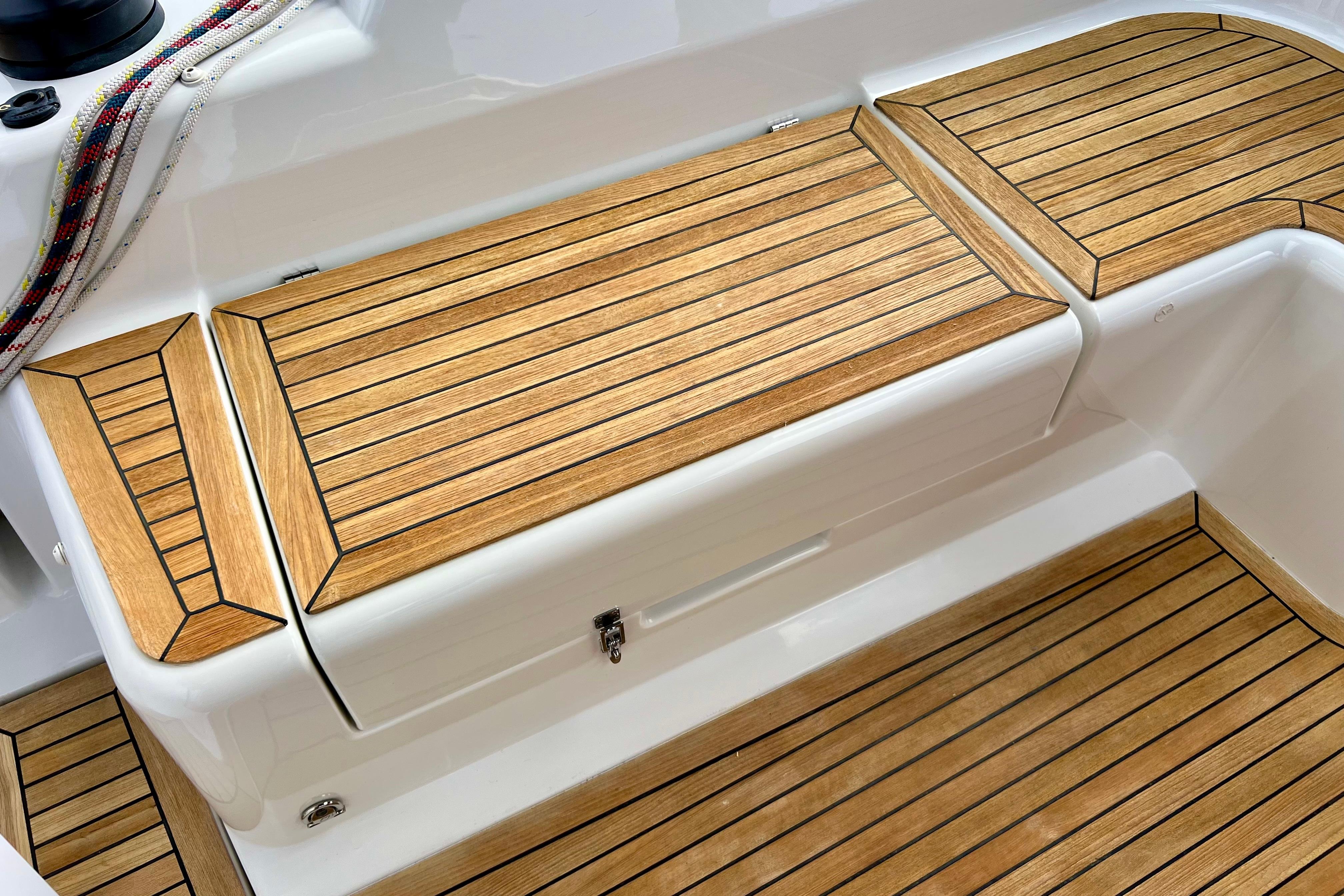 Teak deck of 2016 Hanse 455 yacht, featuring sleek wooden finish and nautical ropes.