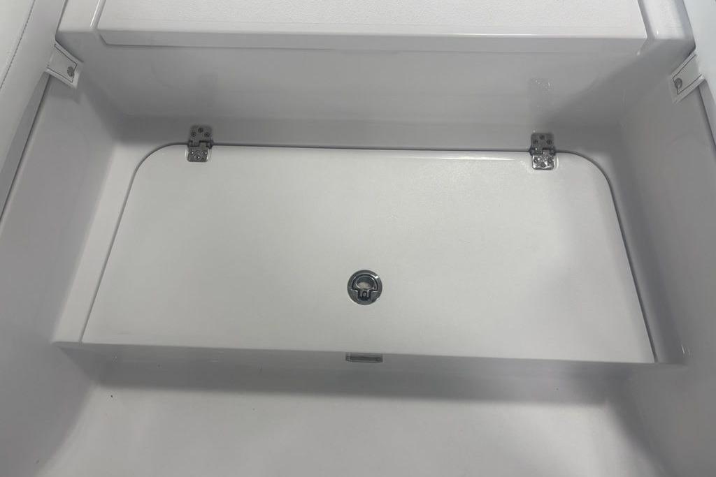Storage compartment of 2026 Sportsman Masters 227 boat, featuring a secure latch and hinges.