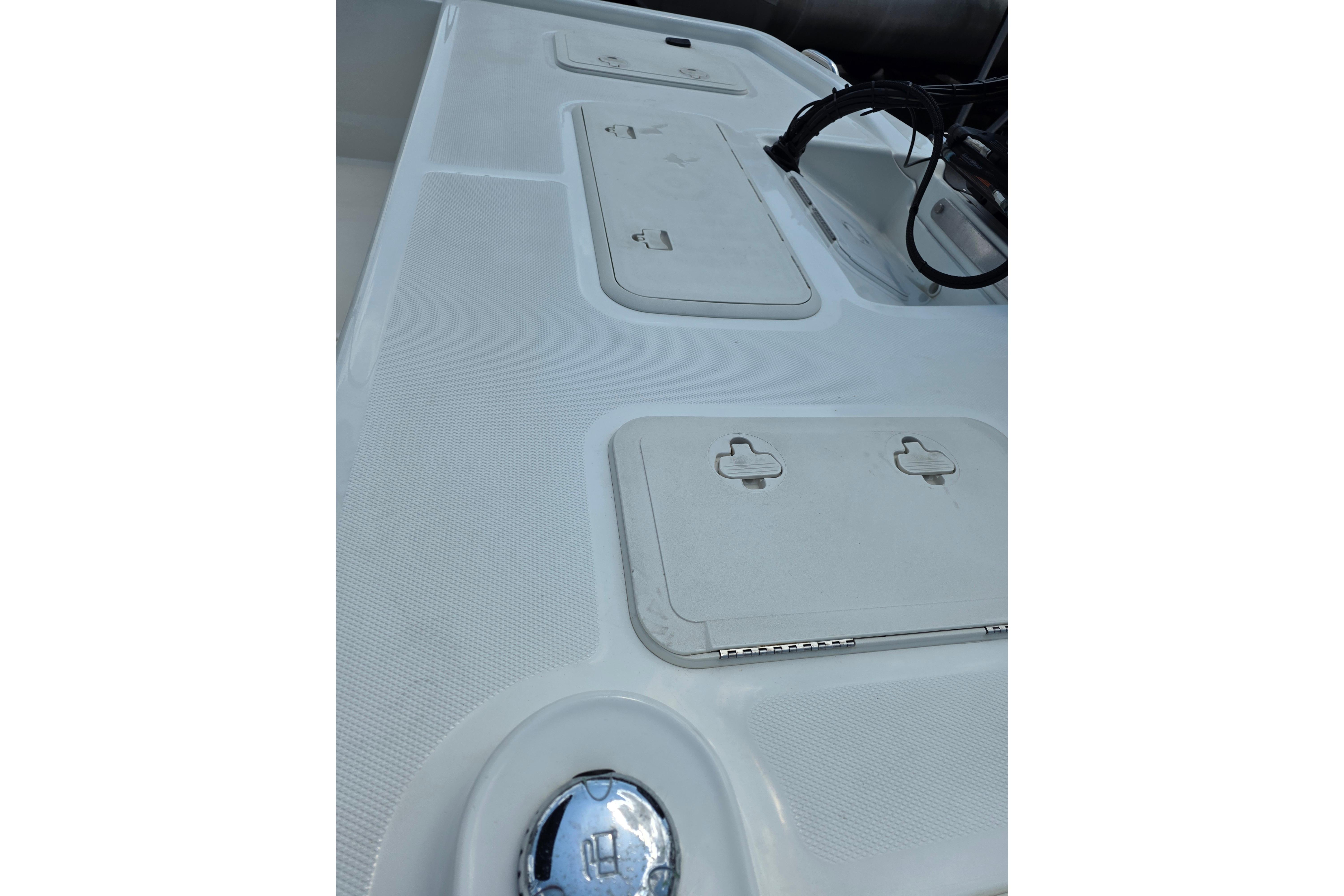 2018 Mako Pro Skiff 19 CC deck with storage compartments and chrome details.