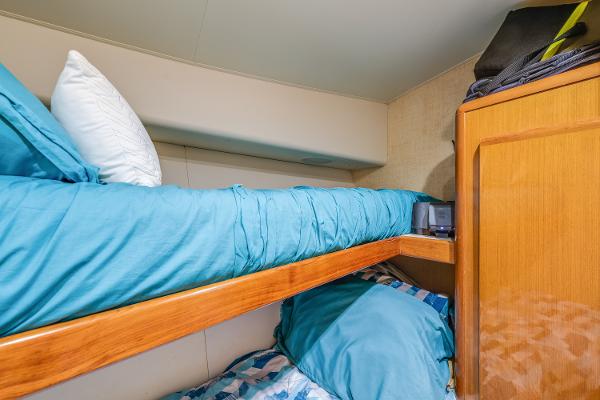 Bunk beds in a 1999 Viking 47 Convertible yacht cabin with blue bedding.
