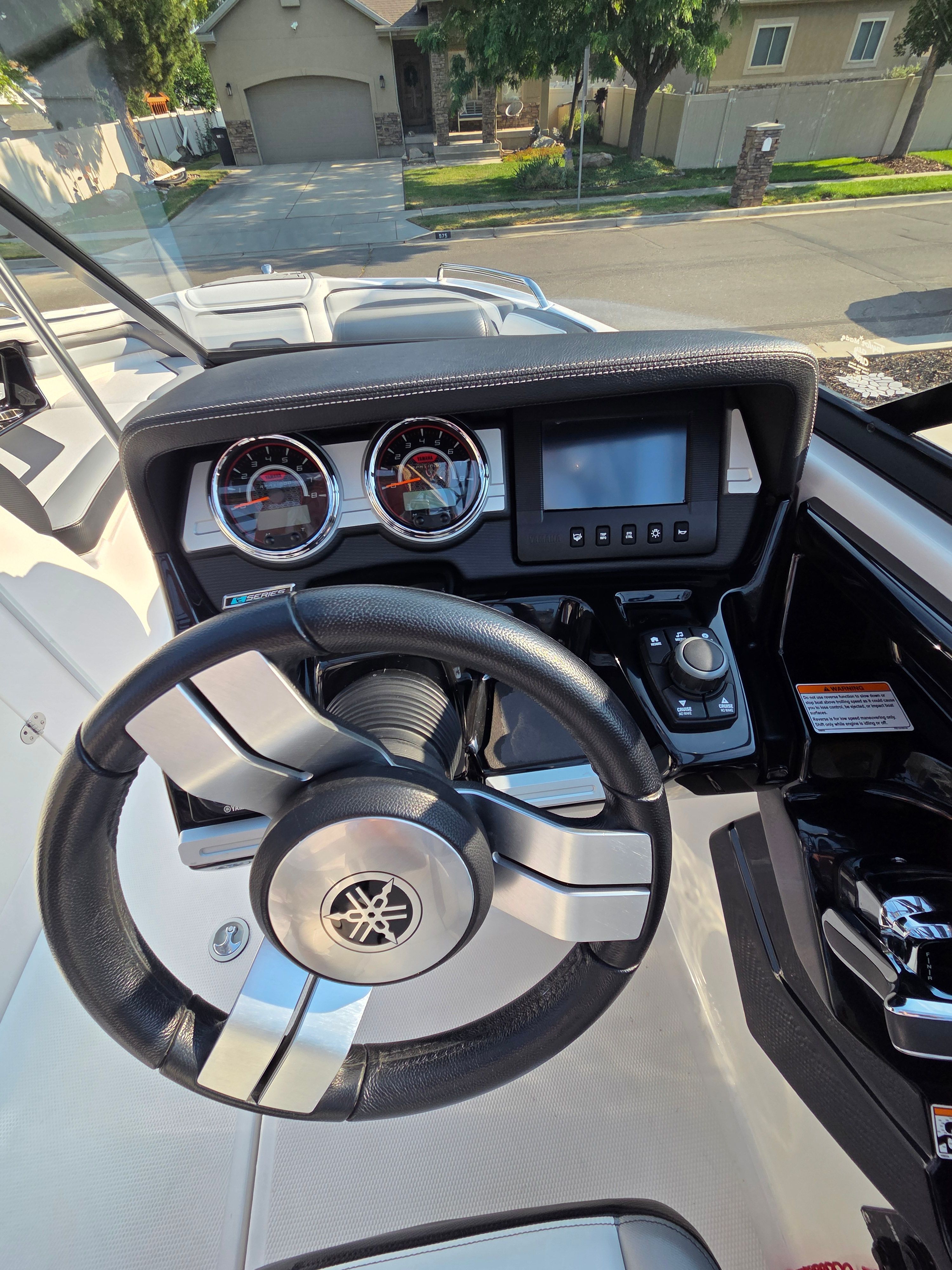 The image shows the helm of a 2016 Yamaha 242X E-Series boat with modern instruments.