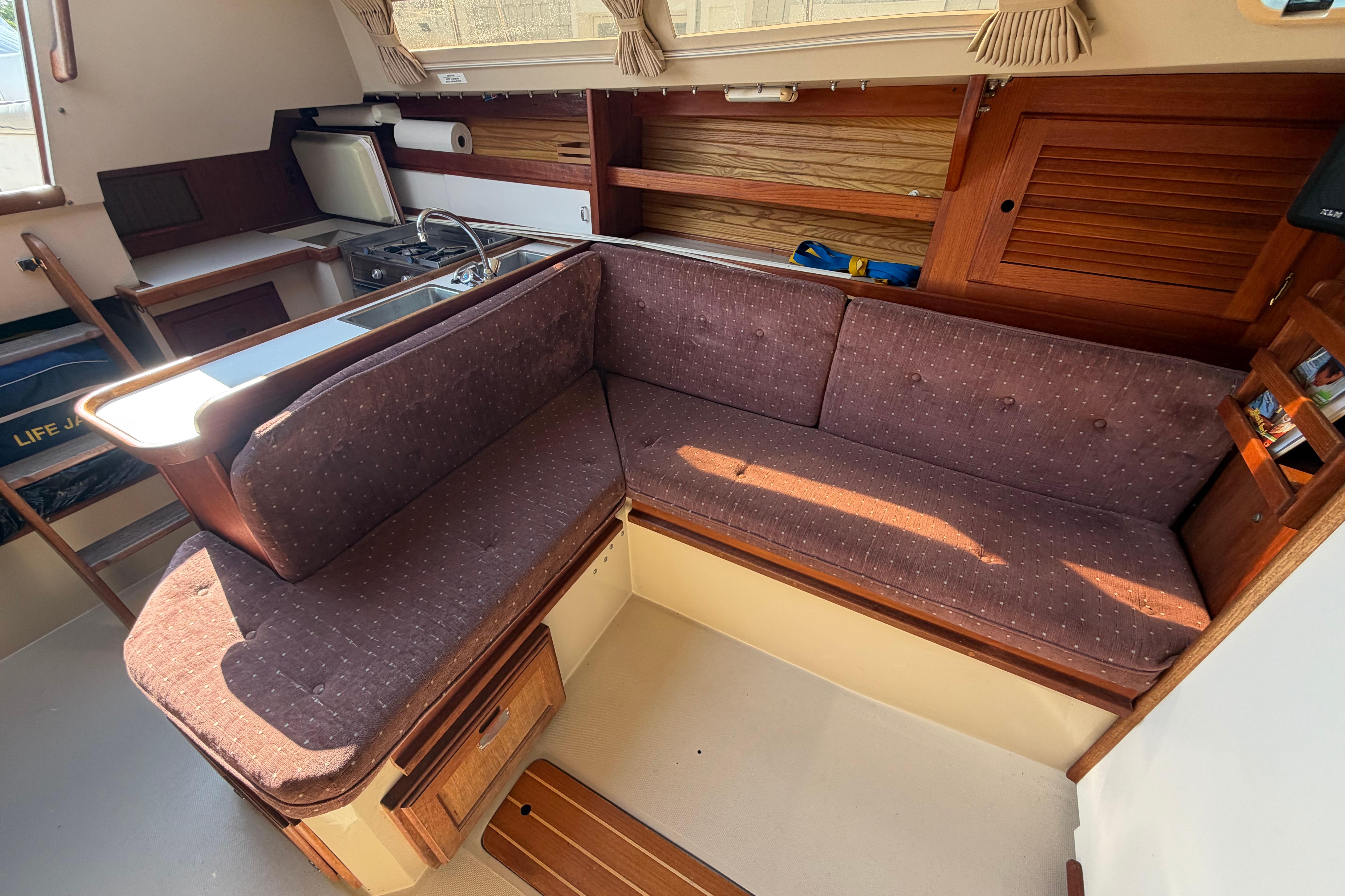 Interior of a 1988 Catalina 30 MkII sailboat with cozy seating and wooden accents.