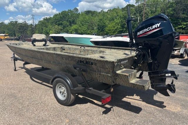 2026 Tracker Grizzly 1654 T Sportsman boat with Mercury engine on trailer, outdoors.