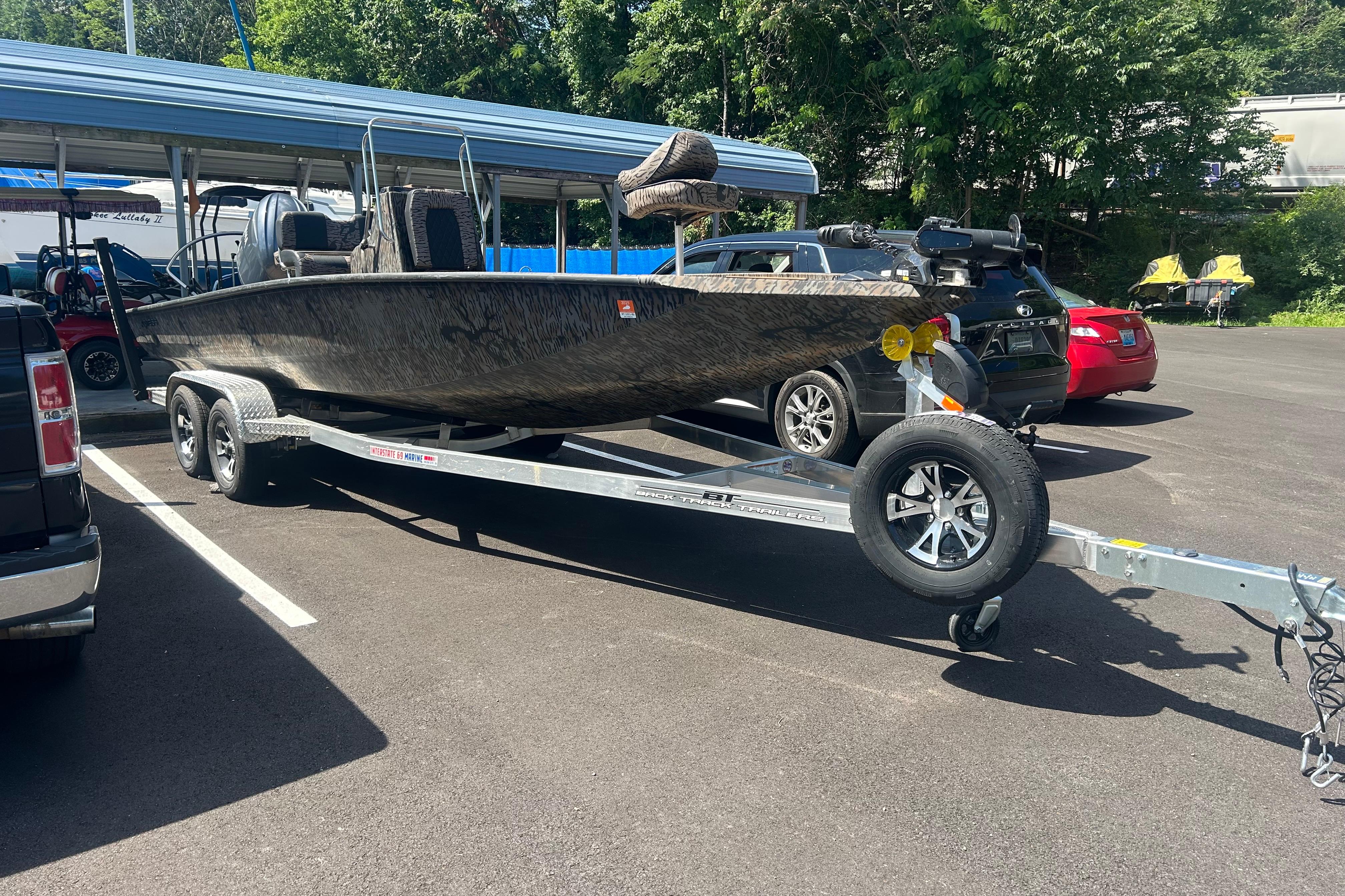 2025 Xpress H22B Bay boat on trailer in parking lot, surrounded by cars.