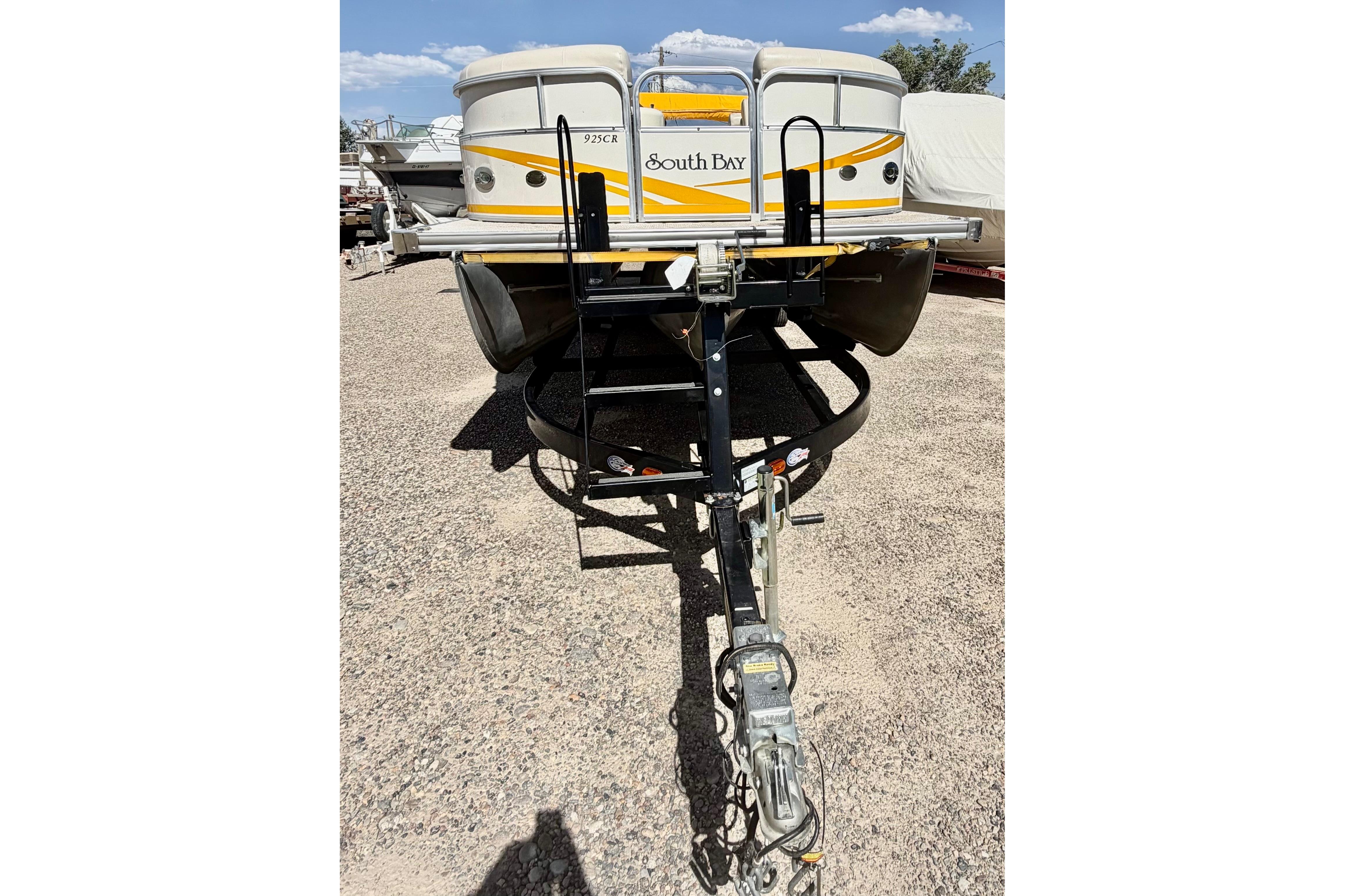 2006 South Bay 925CR pontoon boat on trailer, parked on gravel.