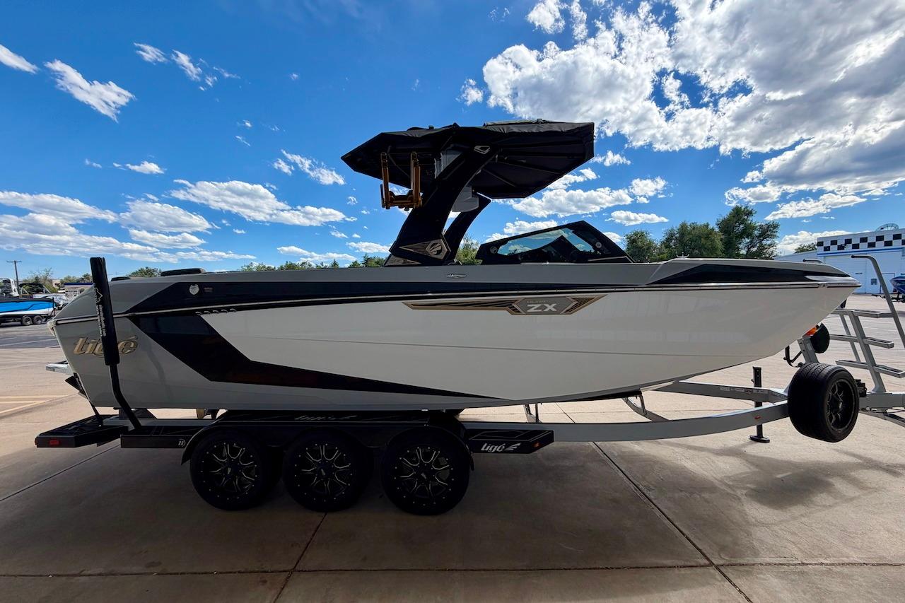2025 Tigé Ultré 25ZX boat on trailer under blue sky with clouds.