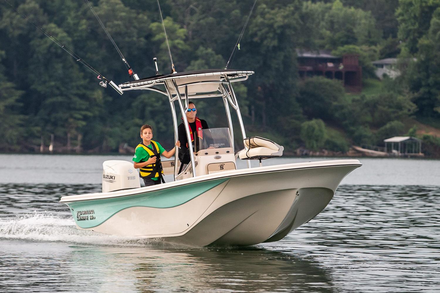 Manufacturer Provided Image: 2026 Carolina Skiff 19 LS boat cruising on a lake with two passengers, surrounded by lush greenery.