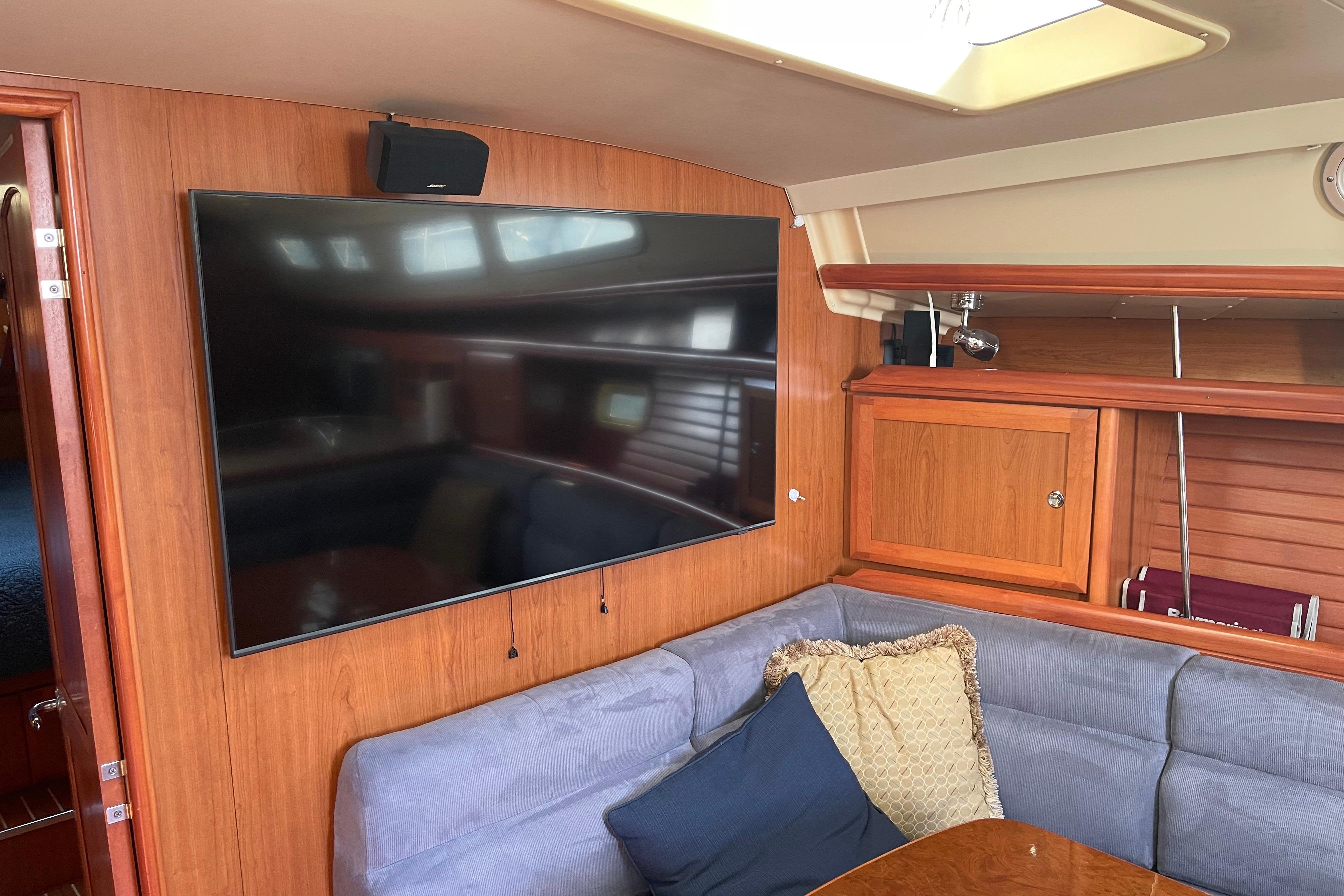 Interior of 2008 Hunter 49 yacht with TV, wooden cabinetry, and cushioned seating.