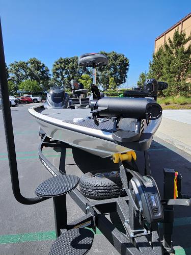 2025 Tracker Savage 215 boat on trailer in parking lot, sunny day.