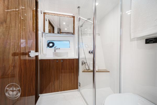 Luxurious bathroom in 2025 Riviera 645 SUV yacht with modern fixtures and wooden accents.