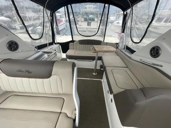 2014 Sea Ray 310 Sundancer interior with seating and table, docked at marina.