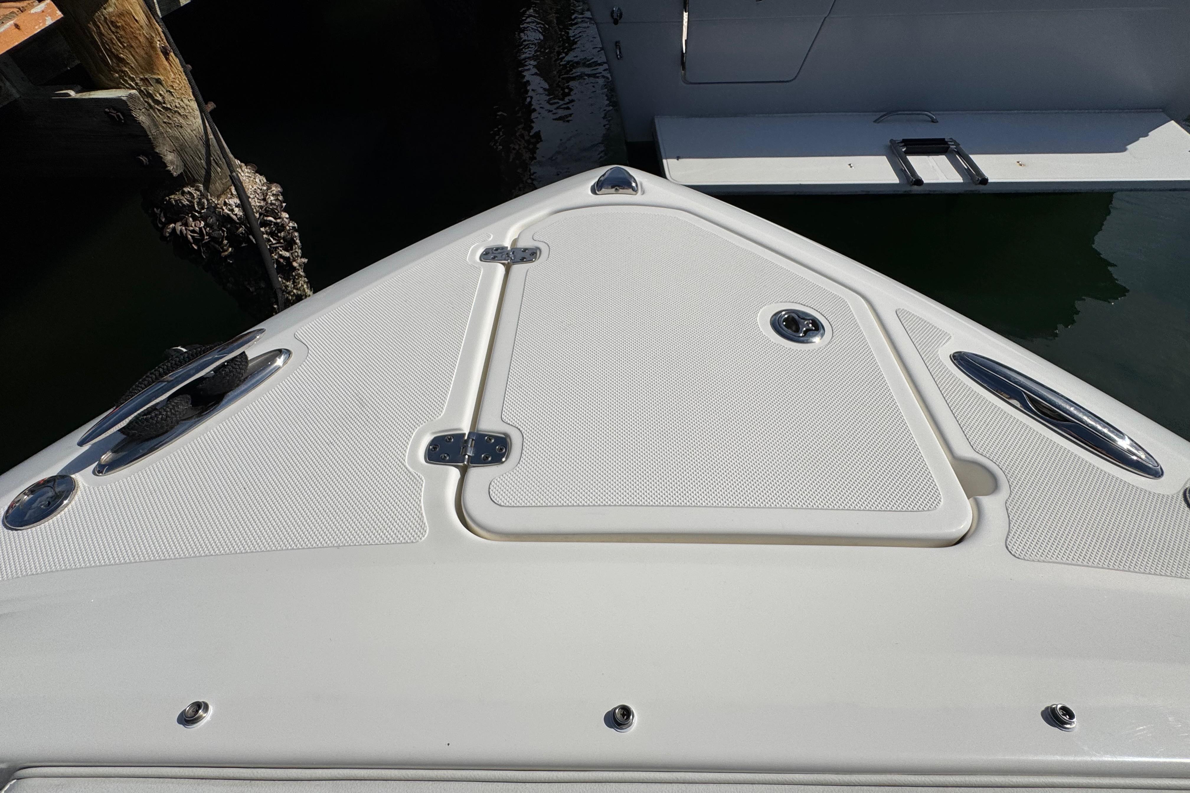 2022 Pursuit DC 266 Dual Console boat deck with storage hatch and cleats.