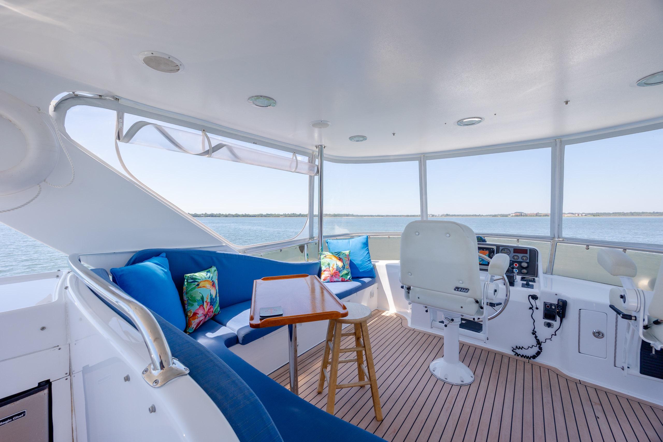 Luxurious 2005 Ocean Alexander 52 Sedan yacht interior with seating and helm, overlooking serene waters.