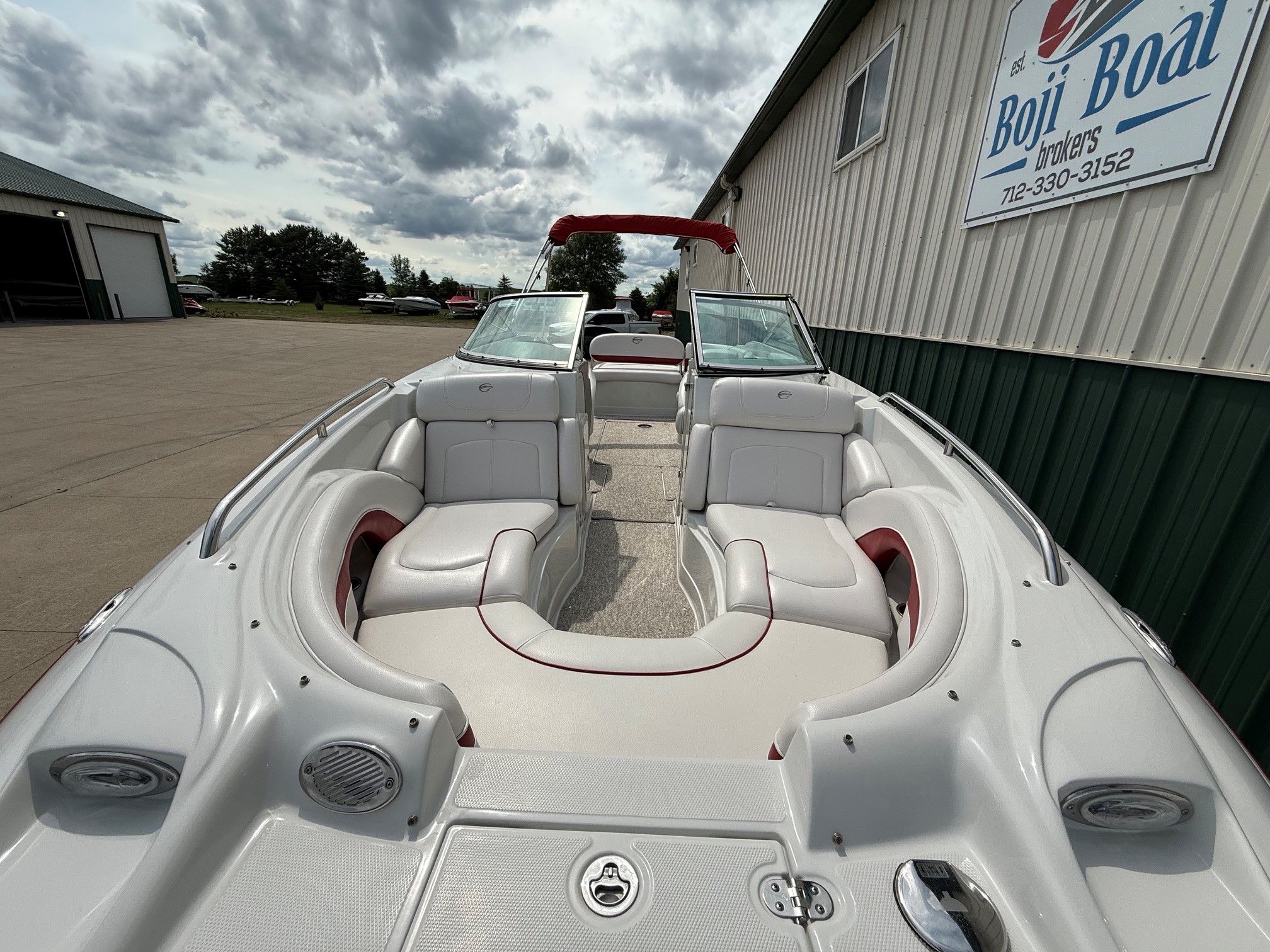 The image shows a 2012 Crownline 252 EX boat with a spacious deck and comfortable seating.
