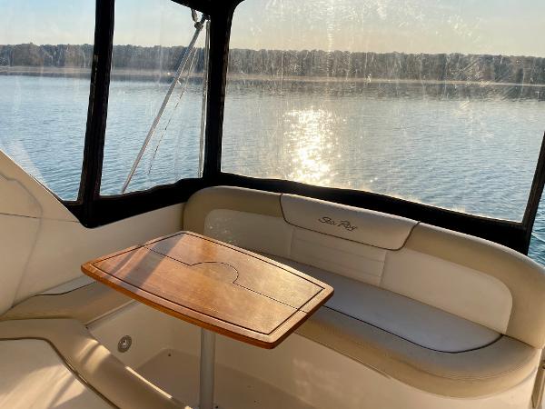 2014 Sea Ray 330 Sundancer interior with table, overlooking serene water view.
