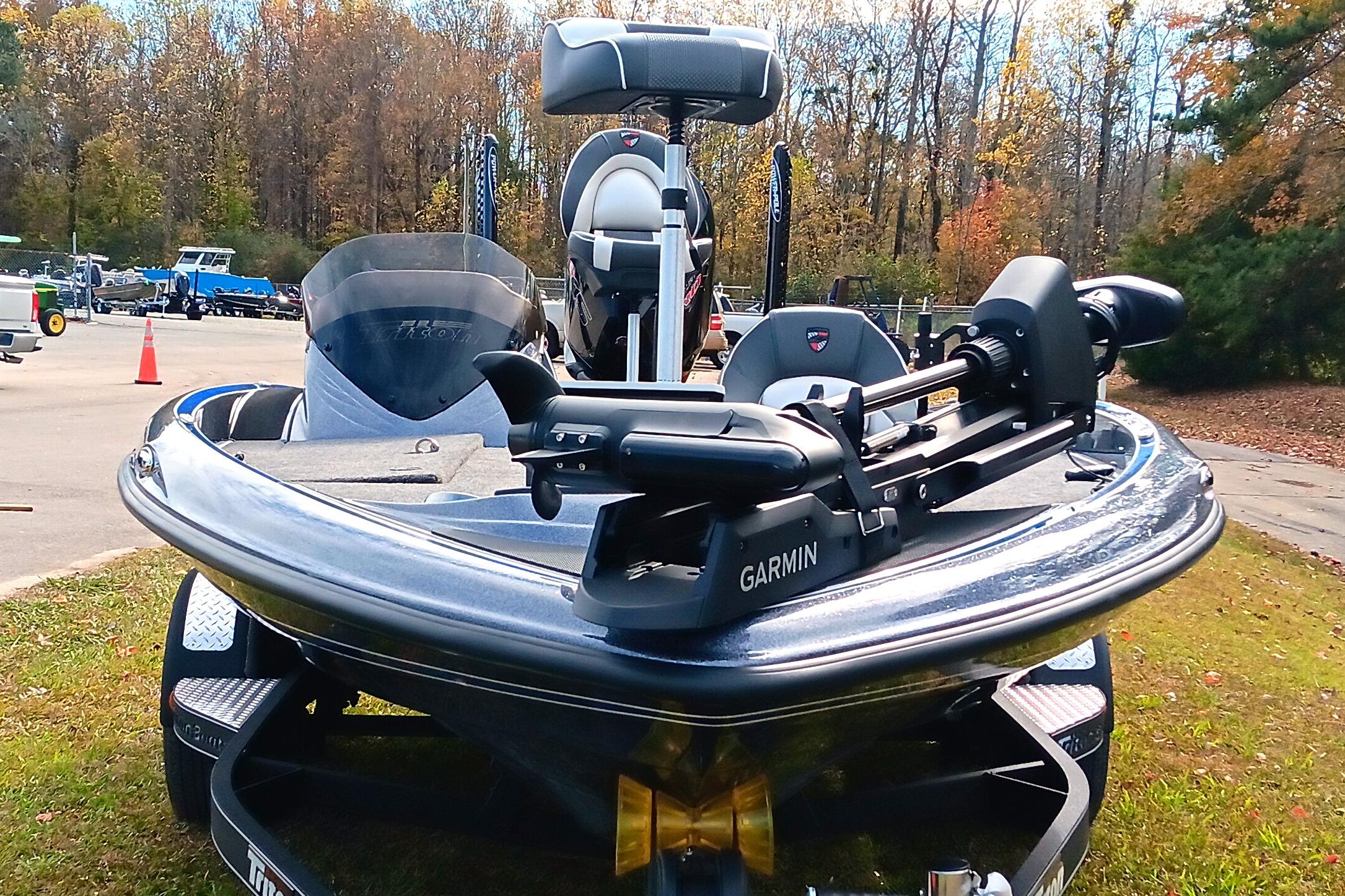 2026 Triton 18 TrX boat with Garmin equipment, parked outdoors on grass.