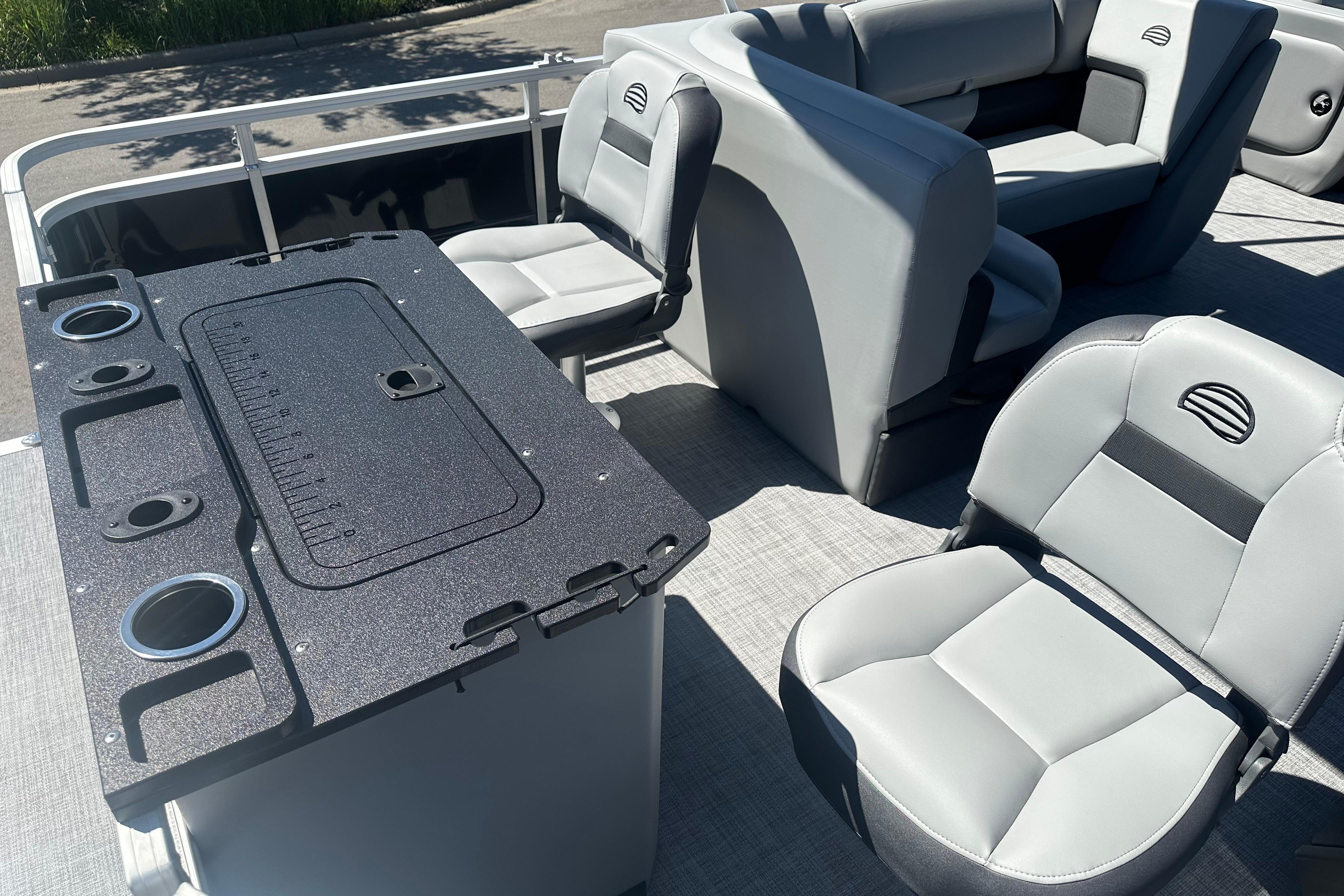 Interior of 2026 Sun Tracker SportFish 22 DLX pontoon boat with seating and table.