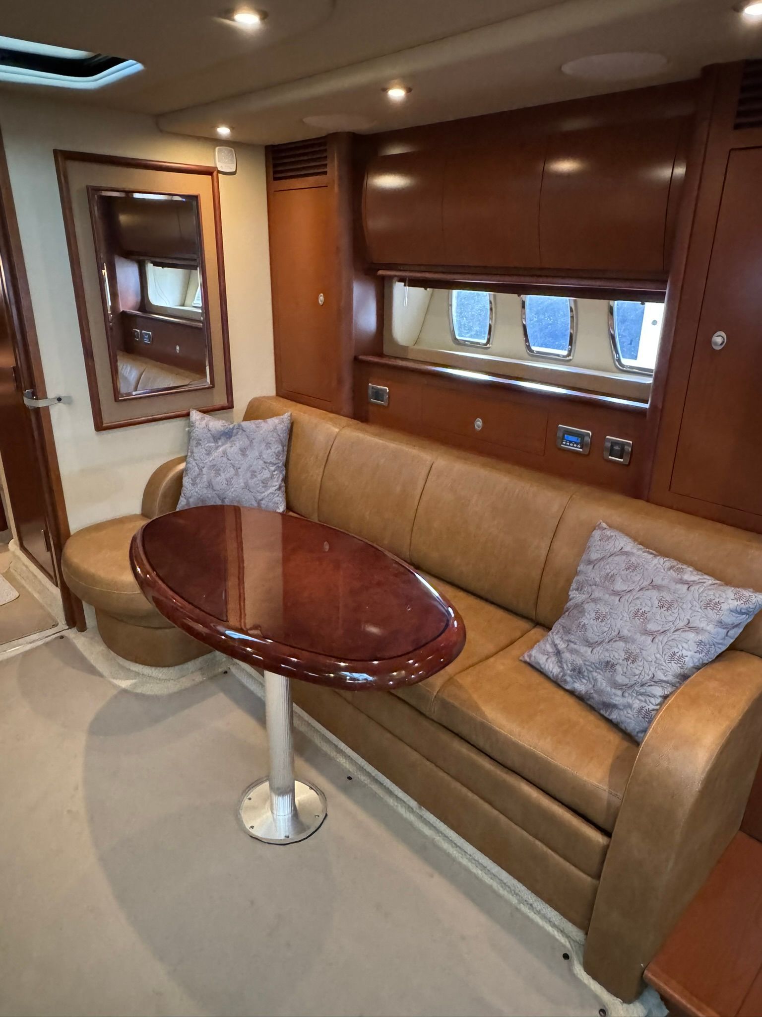 Interior of the 2007 Sea Ray 40 Sundancer with leather sofa and wooden table.