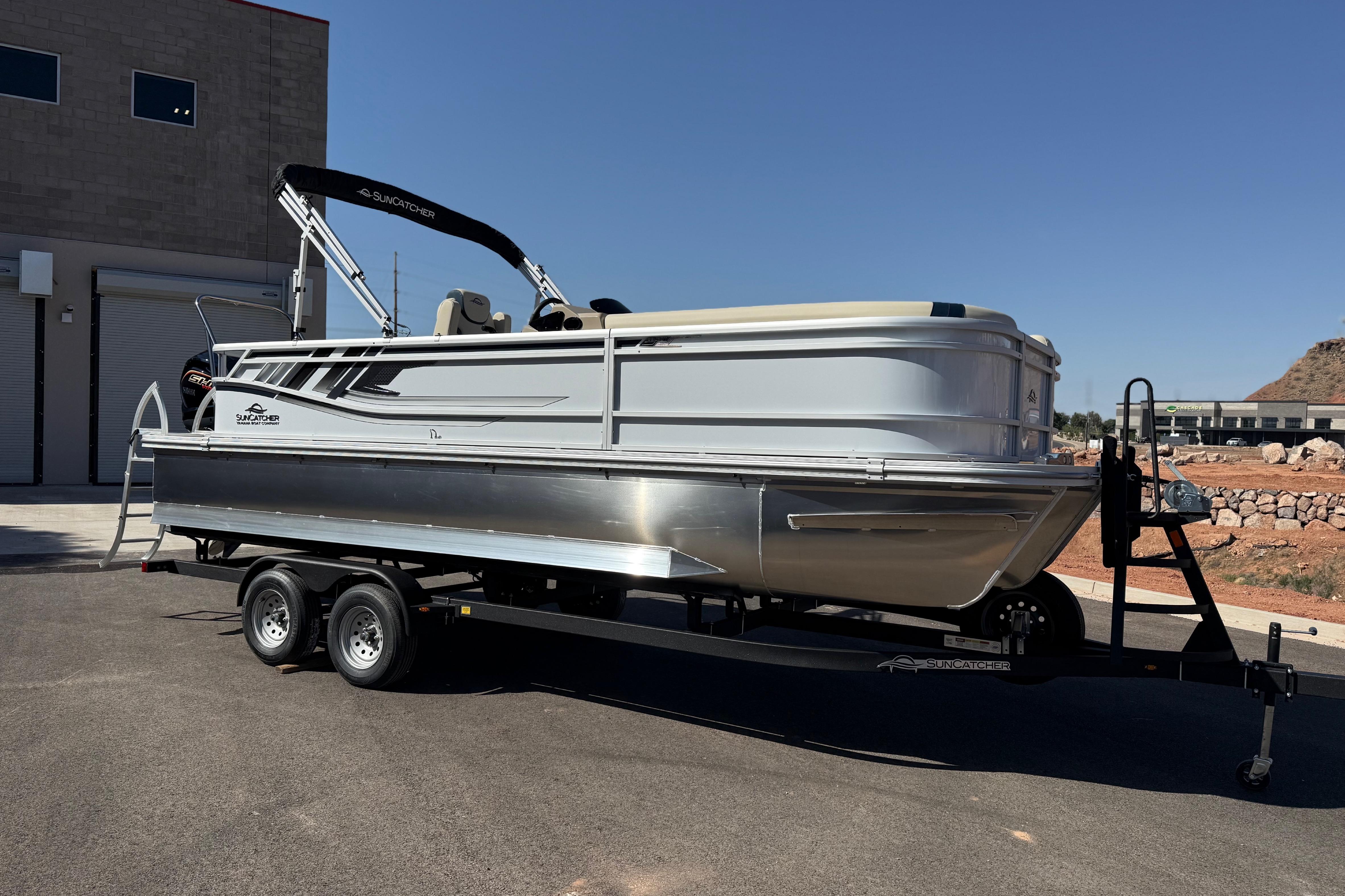 2026 SunCatcher Select 322SL pontoon boat on trailer, parked outdoors under clear sky.
