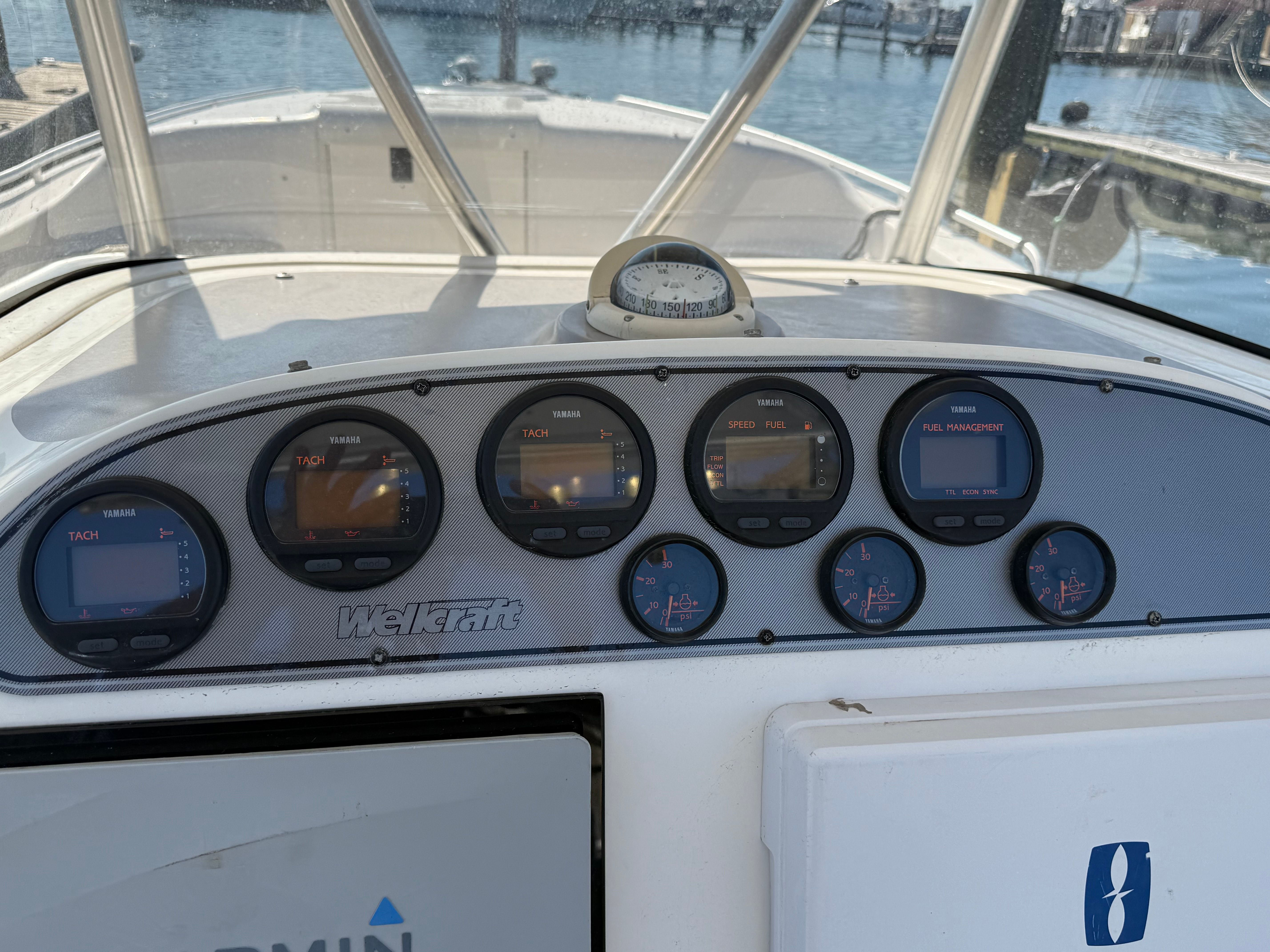 Dashboard of a Wellcraft Scarab 352 sPORT with multiple gauges and a compass.