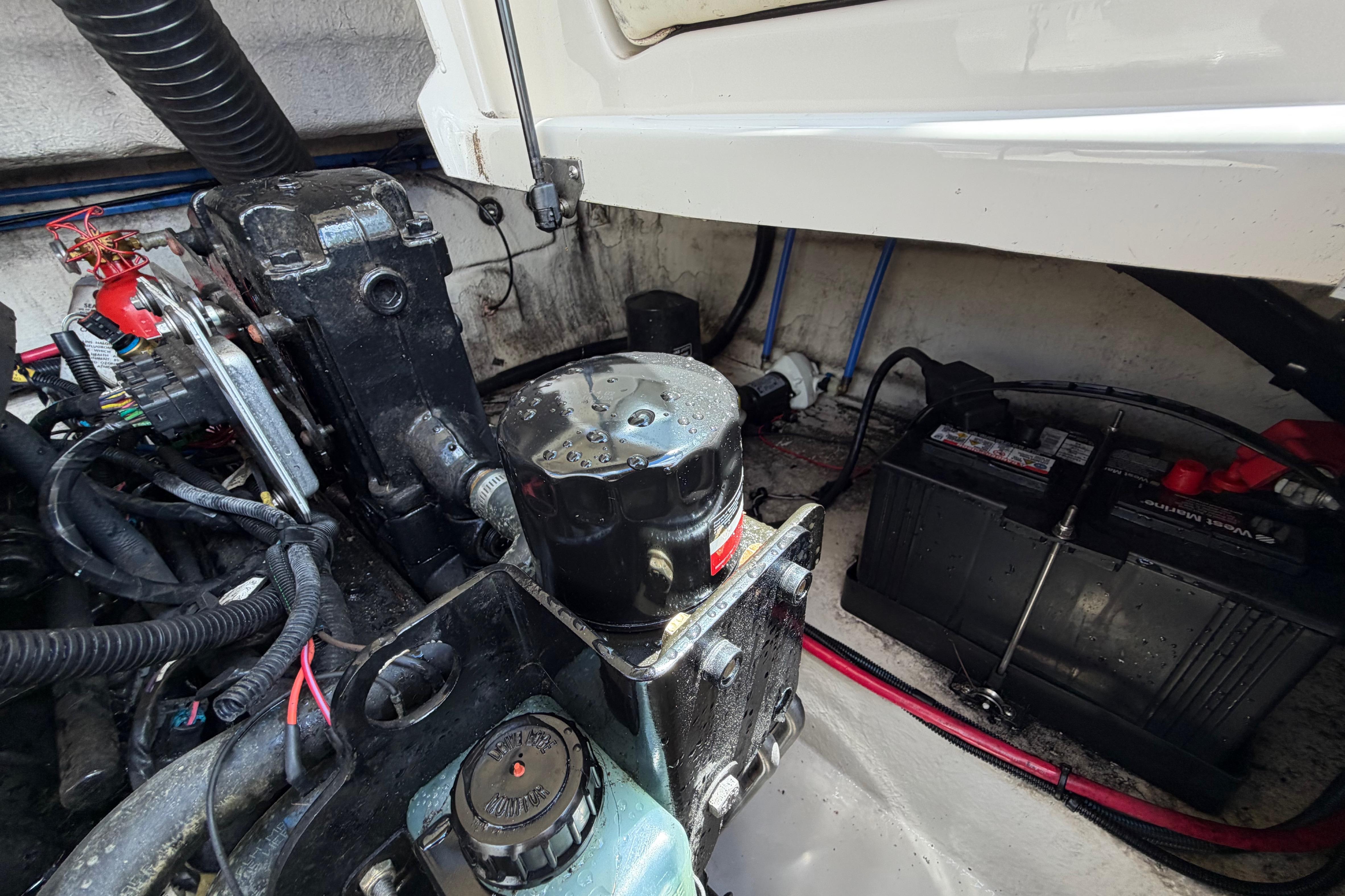 Engine compartment of a 2004 Sea Ray 240 Sundeck with visible battery and wiring.
