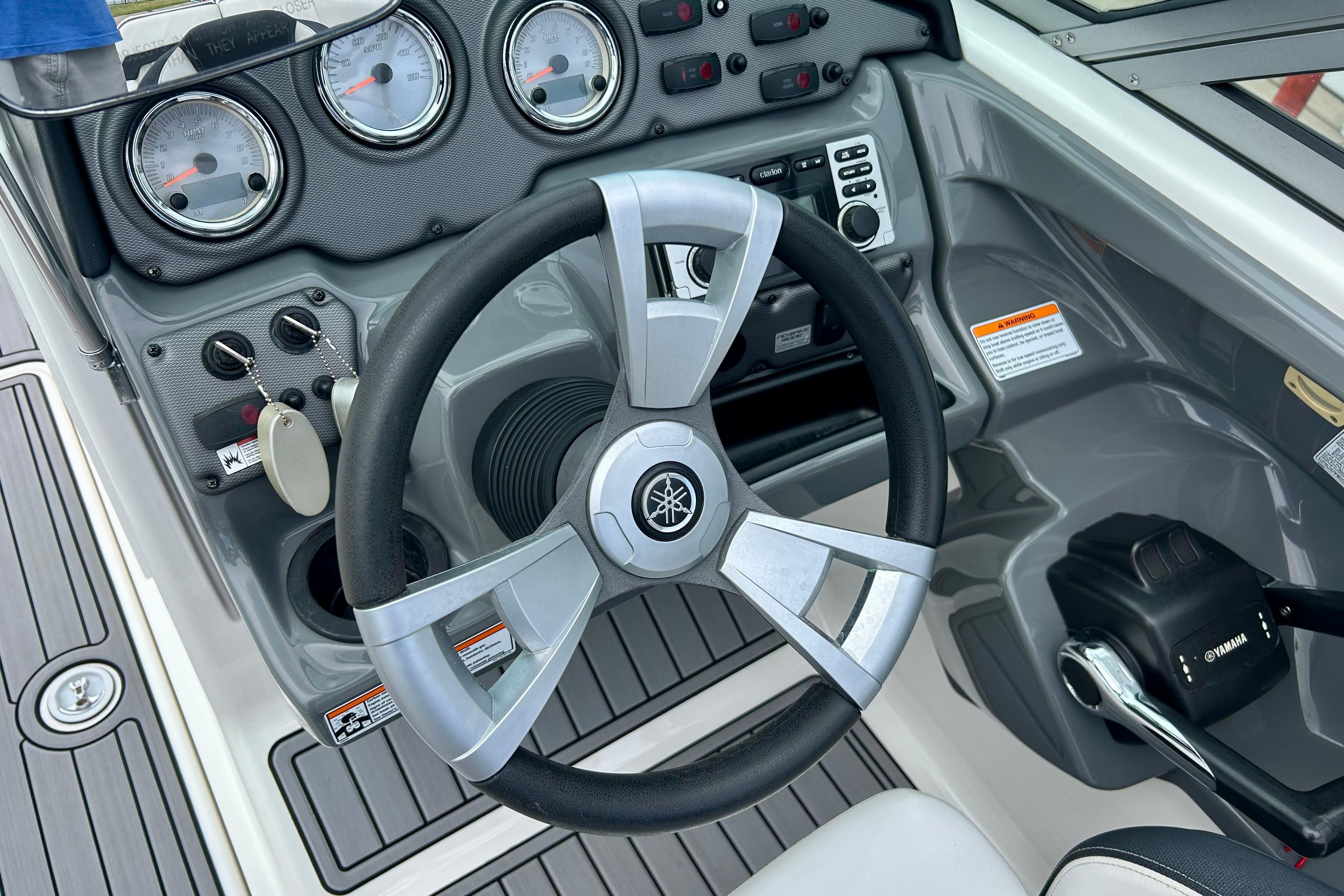 Steering wheel and dashboard of 2015 Yamaha AR210 boat cockpit.