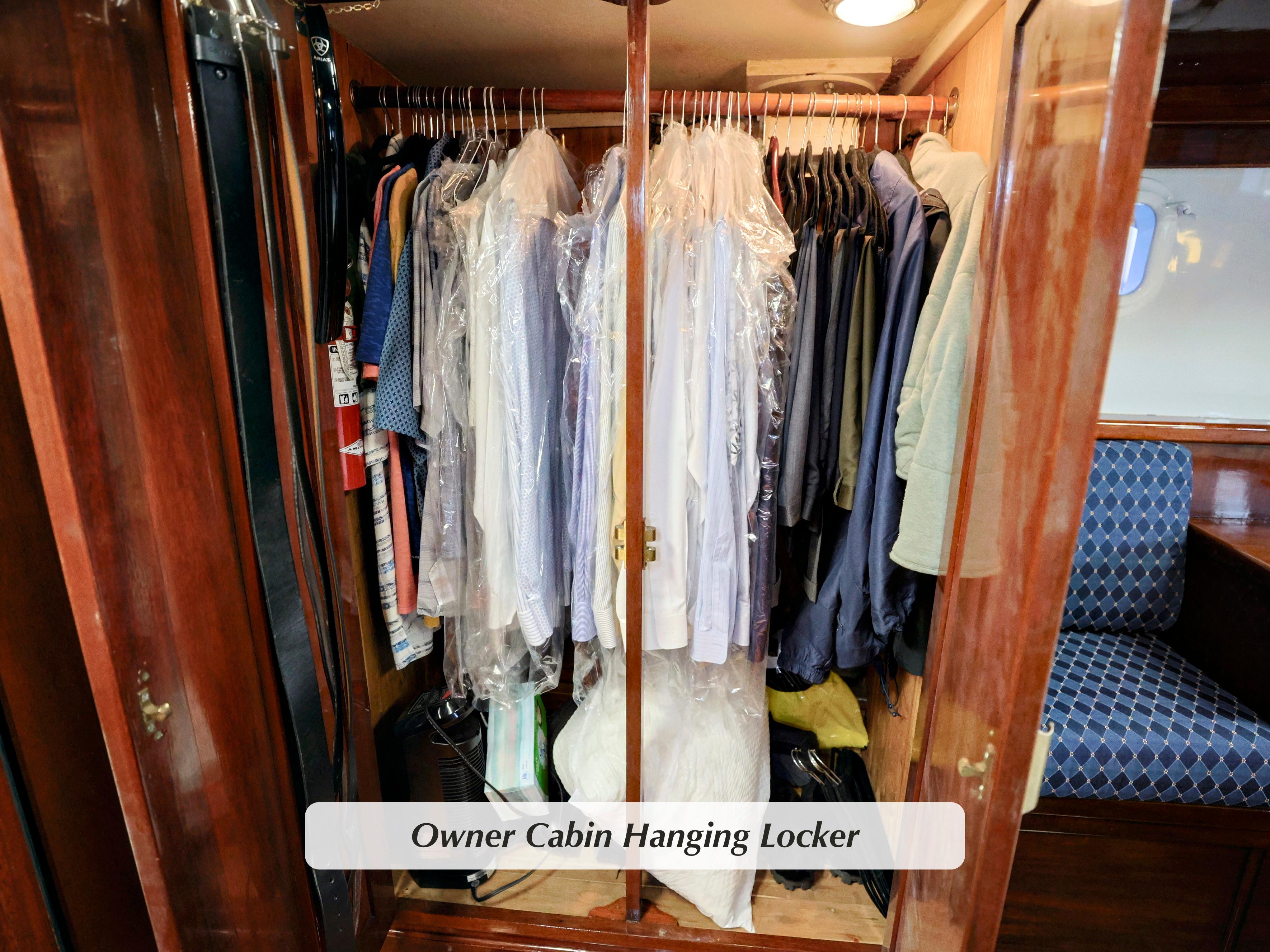 Owner cabin hanging locker on 1968 Stephens Motor Yacht, filled with clothes on hangers.