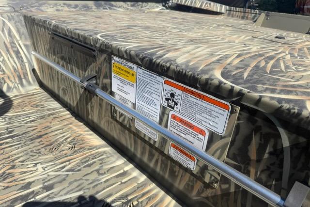 2026 Tracker Grizzly 1860 CC boat with camouflage design and safety labels.