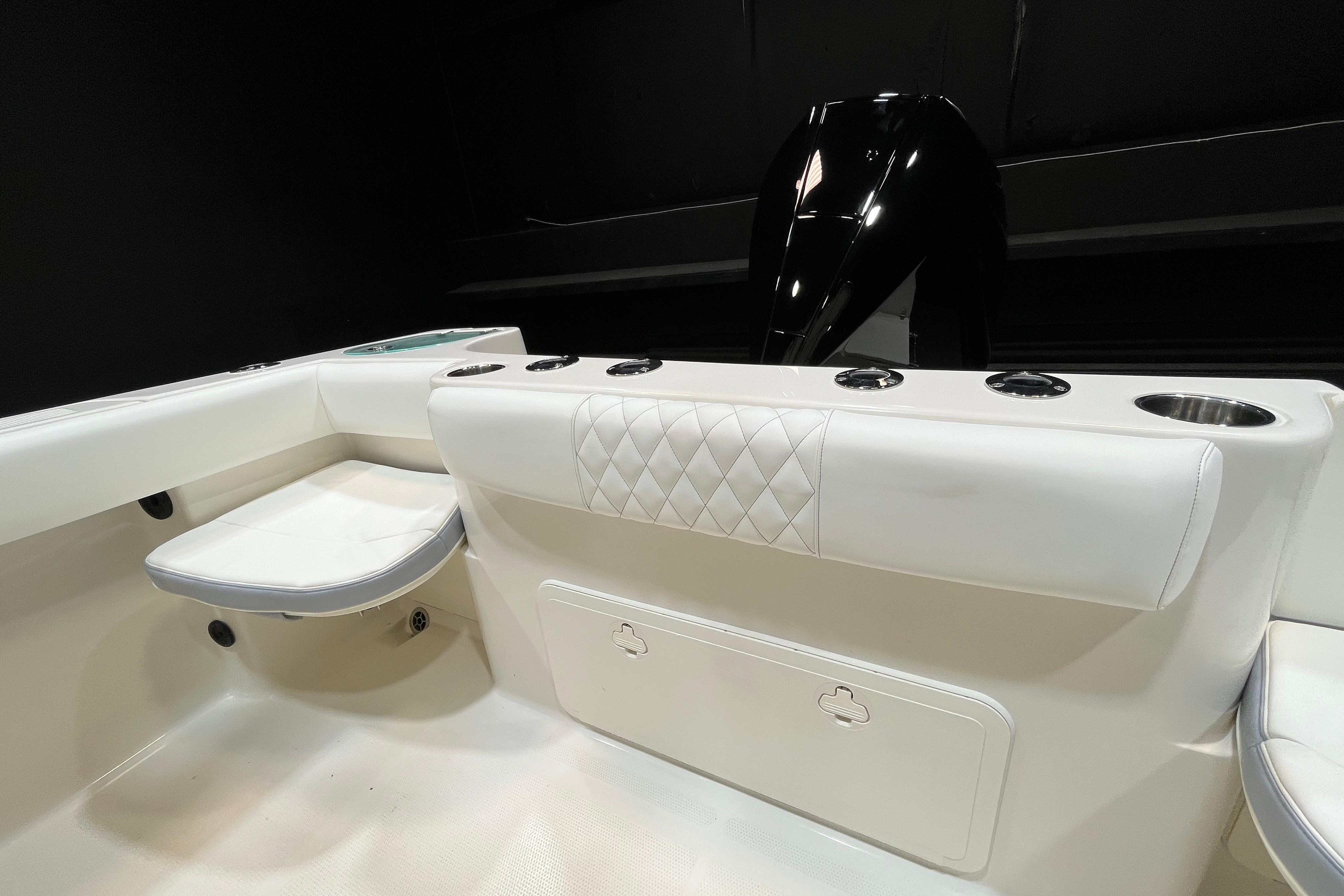 Interior view of 2022 Sailfish 242 CC boat, featuring white seating and storage compartments.