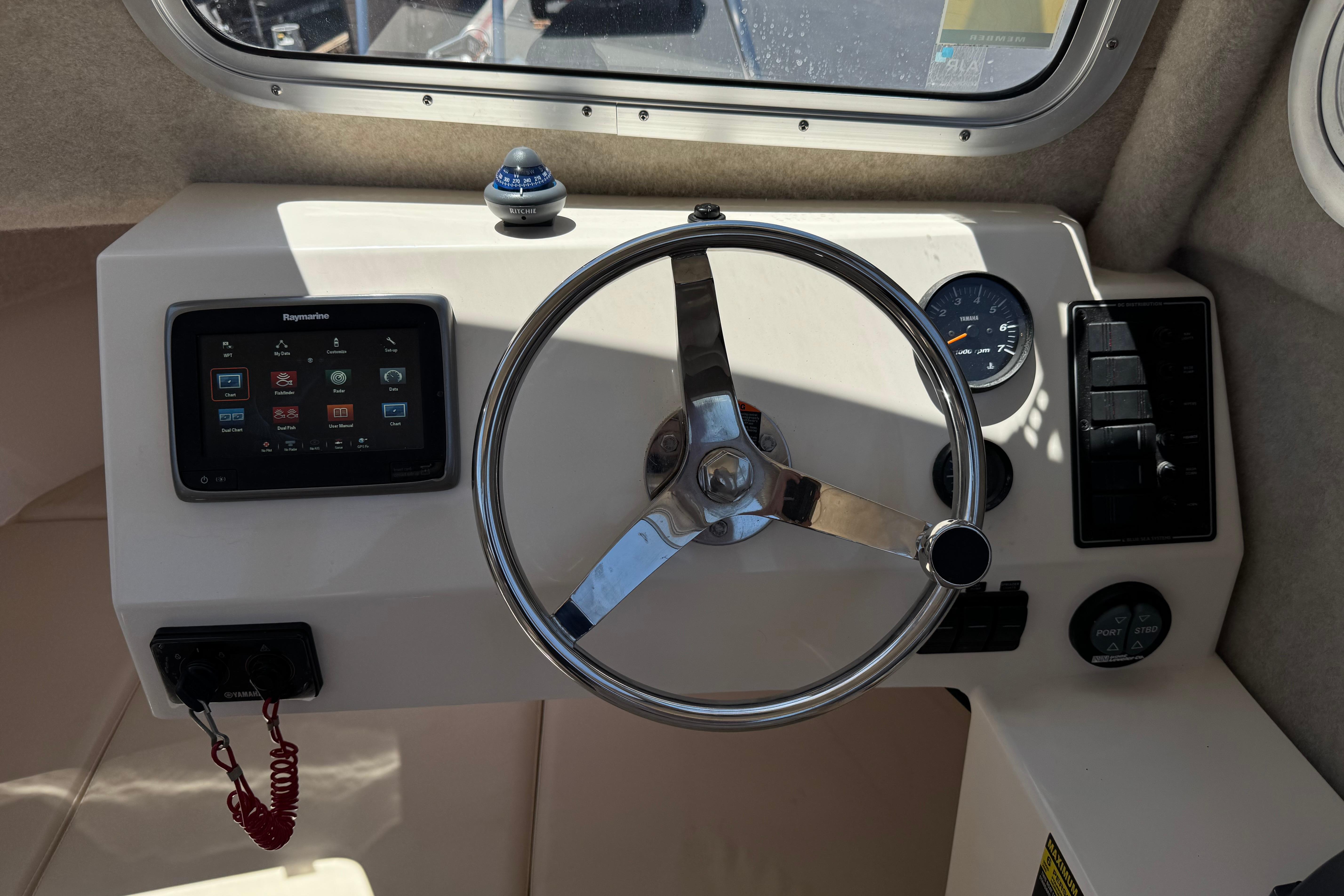 Helm of 2017 Defiance Admiral 220 EX with steering wheel and navigation controls.