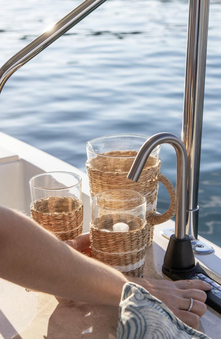 Wicker-wrapped glasses on a Duffy Balboa 20' boat, 2026, near water.