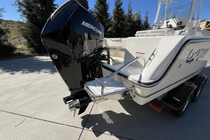 2025 Mako 214 Center Console boat with Mercury engine on trailer, outdoors.