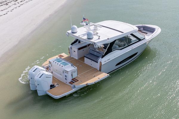 Manufacturer Provided Image: 2026 Regal LX43 luxury boat on calm water near sandy beach.