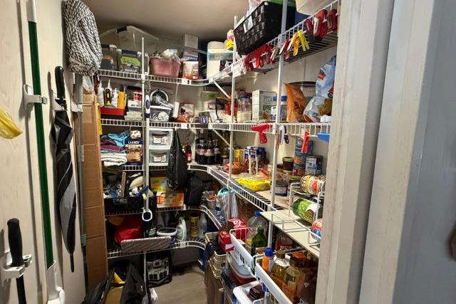 Organized pantry with shelves stocked with food and supplies on a 1997 Stardust Houseboat.